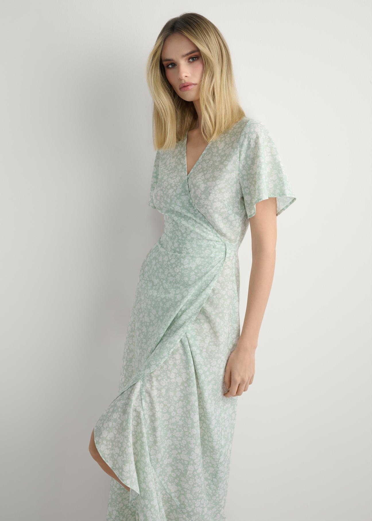 Długa sukienka w kwiaty SUKDT-0233-8P(W26), widok produktu z przodu na modelce. Widoczna połowa sylwetki.