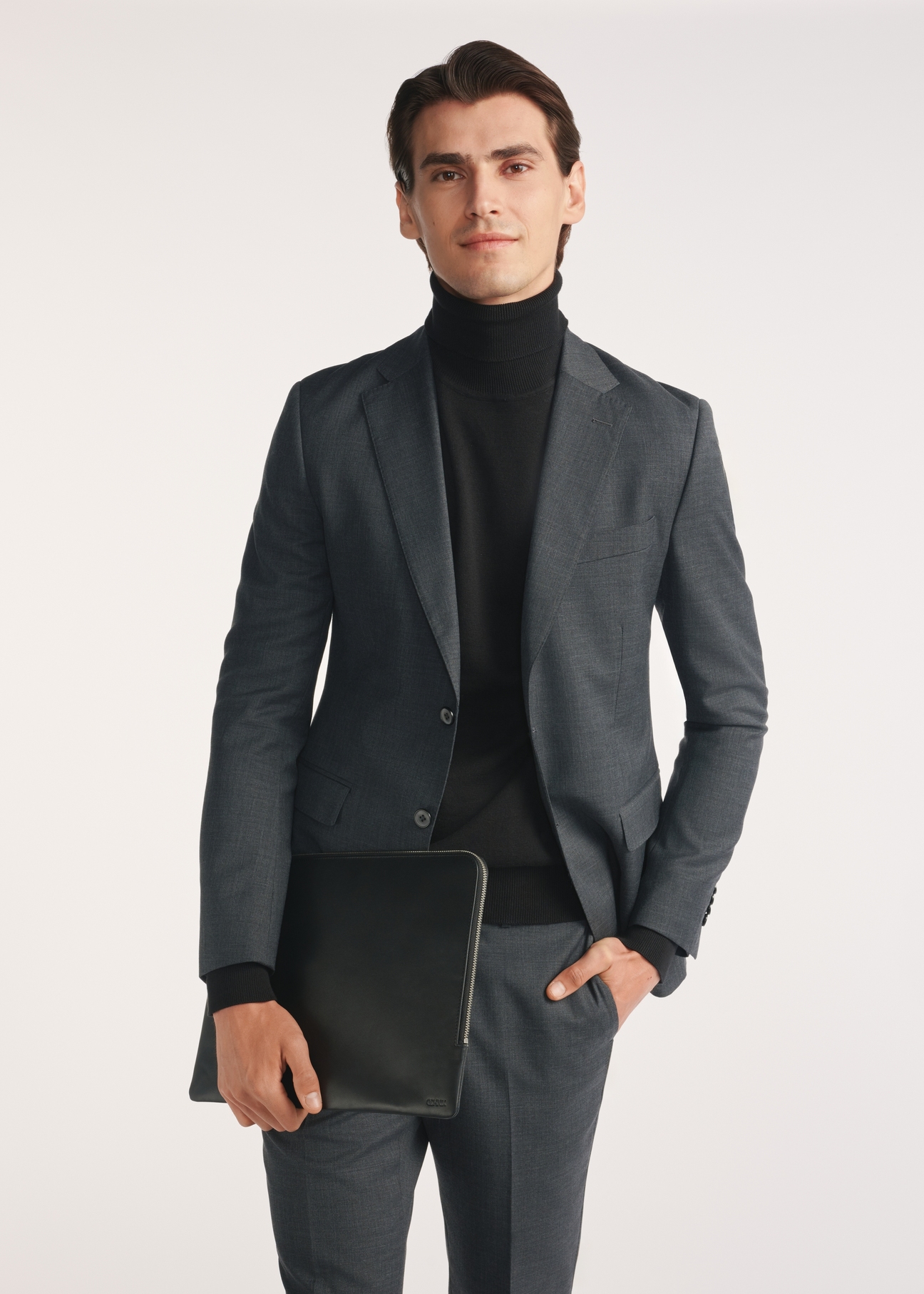 Czarna teczka męska TORMS-0474-99(Z25), widok produktu skosem na modelu, widoczna połowa sylwetki.