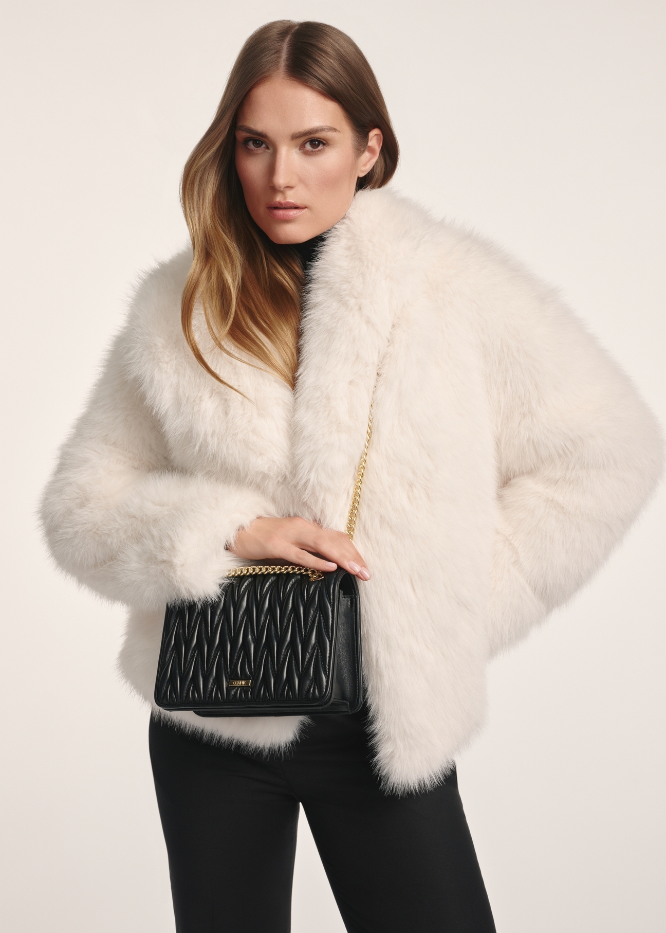 Czarna torebka damska z łańcuszkiem TOREC-1102-99(Z25), widok produktu na modelce. Widoczna połowa sylwetki.