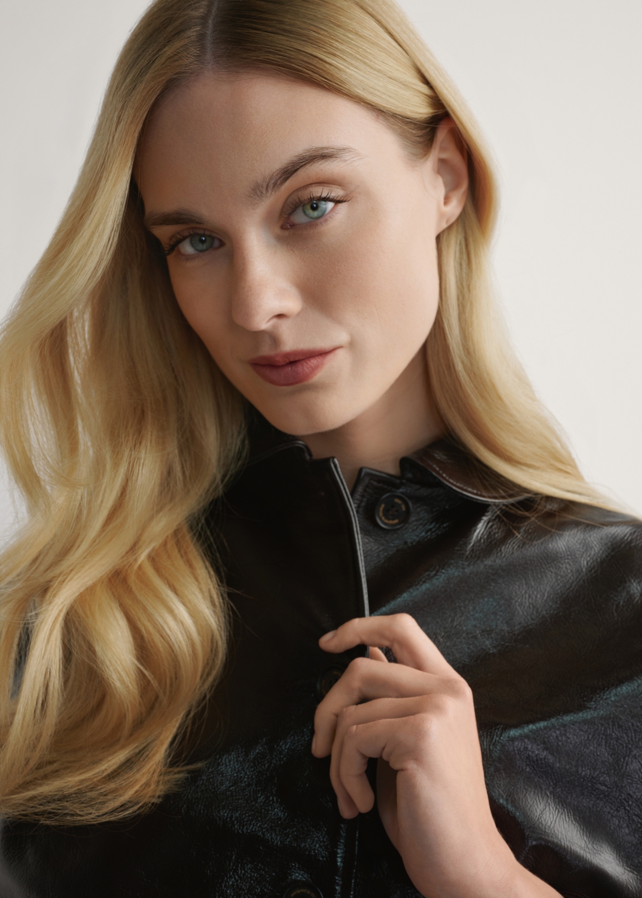 Brązowa skórzana krótka kurtka damska KURDS-0593-1I(W26) - zbliżenie na detal, na jasnym tle. 