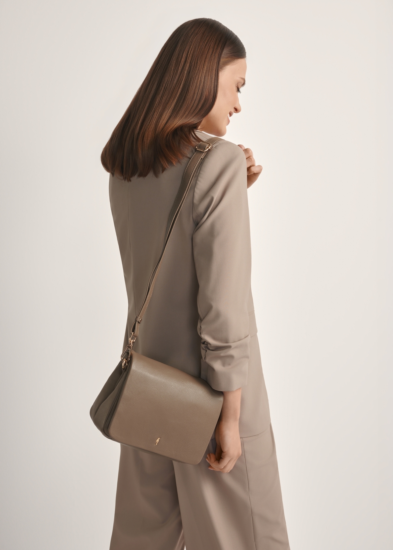 Ciemnobeżowa skórzana torebka damska TORES-0911F-1K(W26), widok produktu od przodu na modelce, widoczna połowa sylwetki.