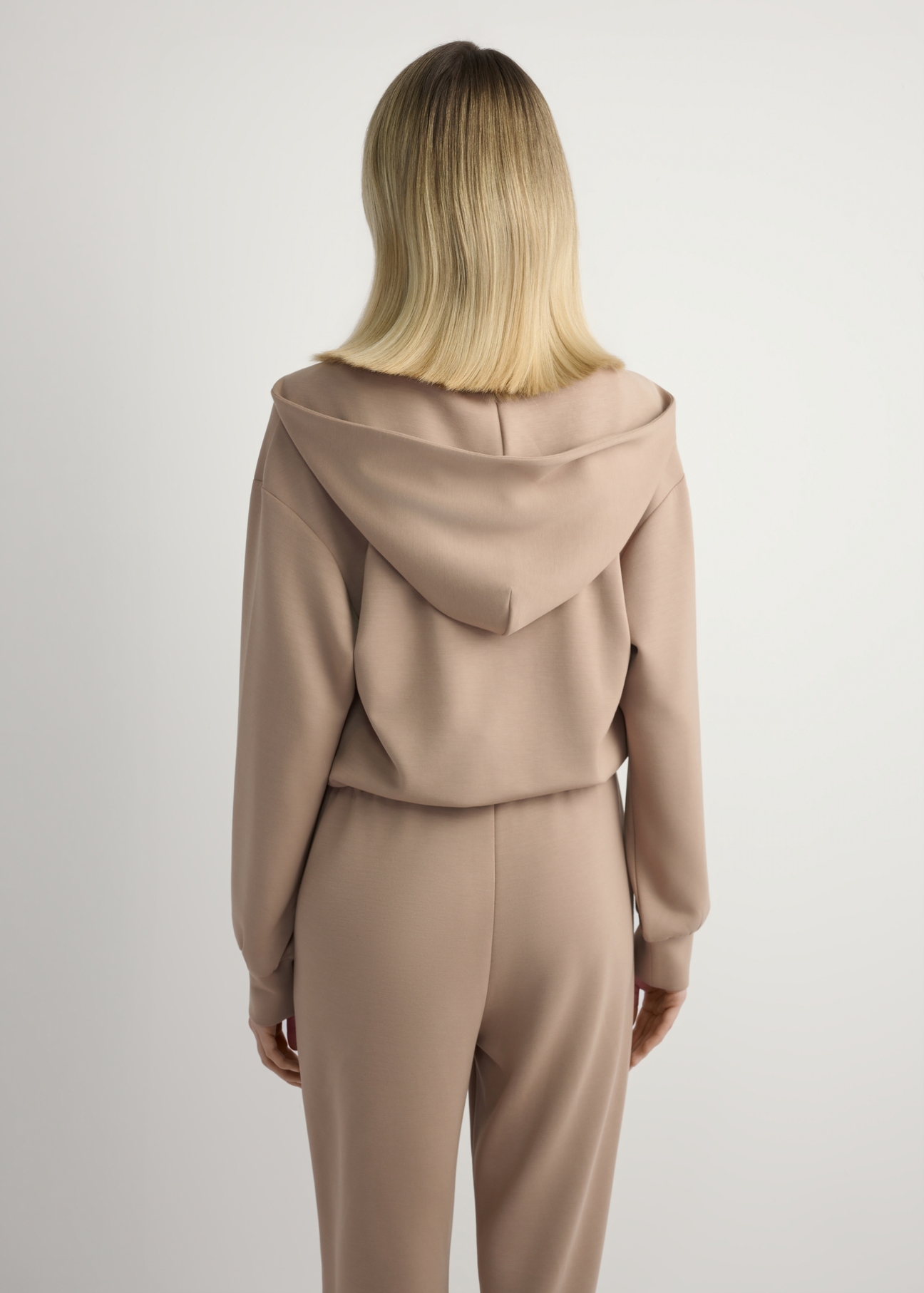 Kamelowa bluza damska z suwakiem BLZDT-0108A-1D(W26), widok produktu z tyłu na modelce. Widoczna połowa sylwetki.