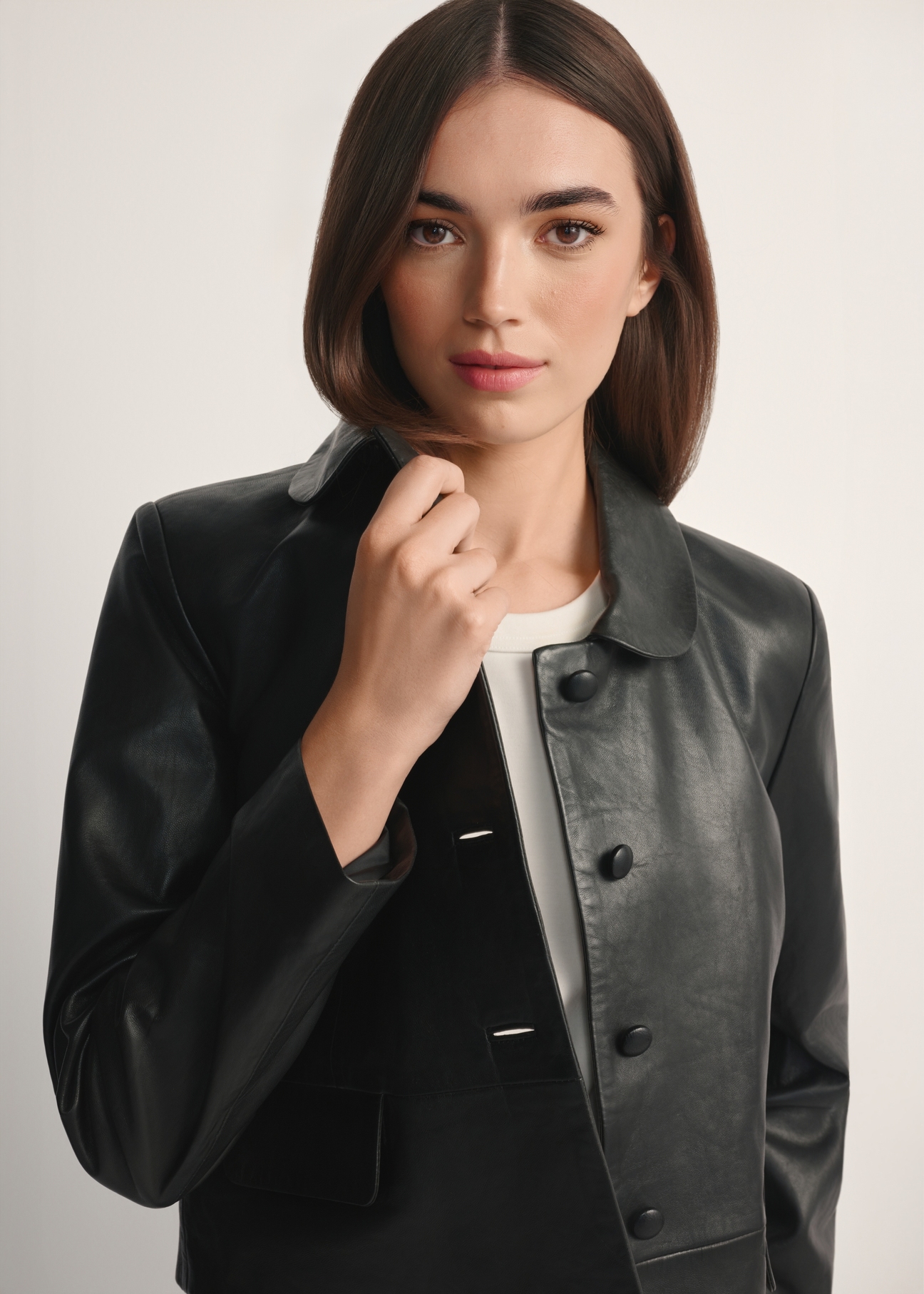 Czarna krótka skórzana kurtka damska KURDS-0598-99(W26), widok produktu od przodem na modelce, widoczna połowa sylwetki.-02