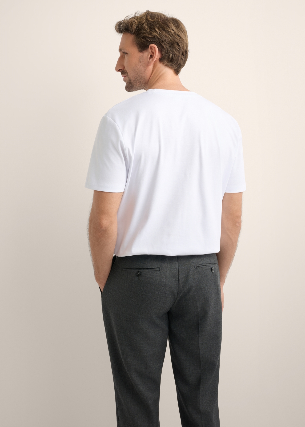 Biały t-shirt męski z bawełny merceryzowanej TSHMT-0156-0A(Z26), widok produktu z tyłu na modelu. Widoczna połowa sylwetki.