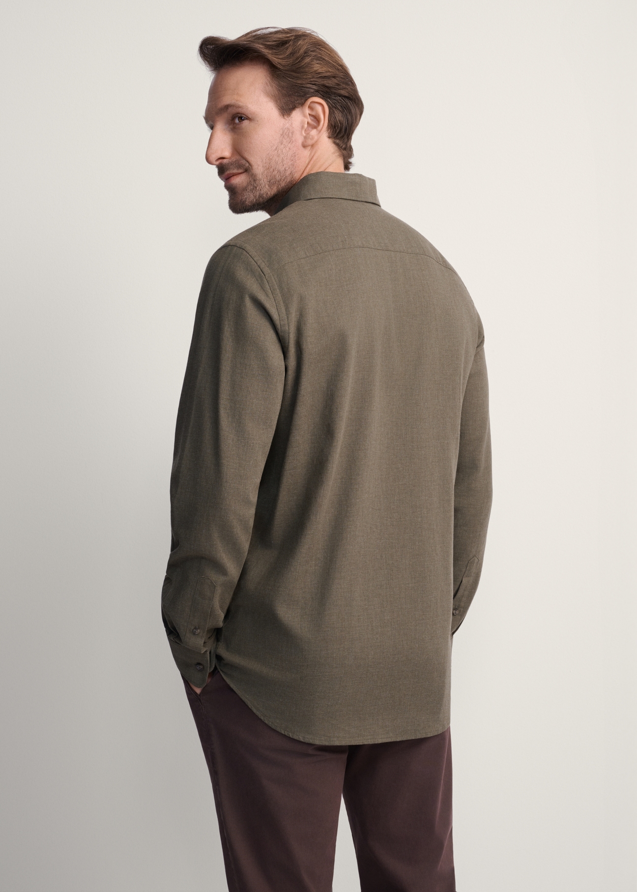Koszula męska w kolorze khaki KOSMT-0299A-55(Z25), widok produktu z tyłu na modelu. Widoczna połowa sylwetki.