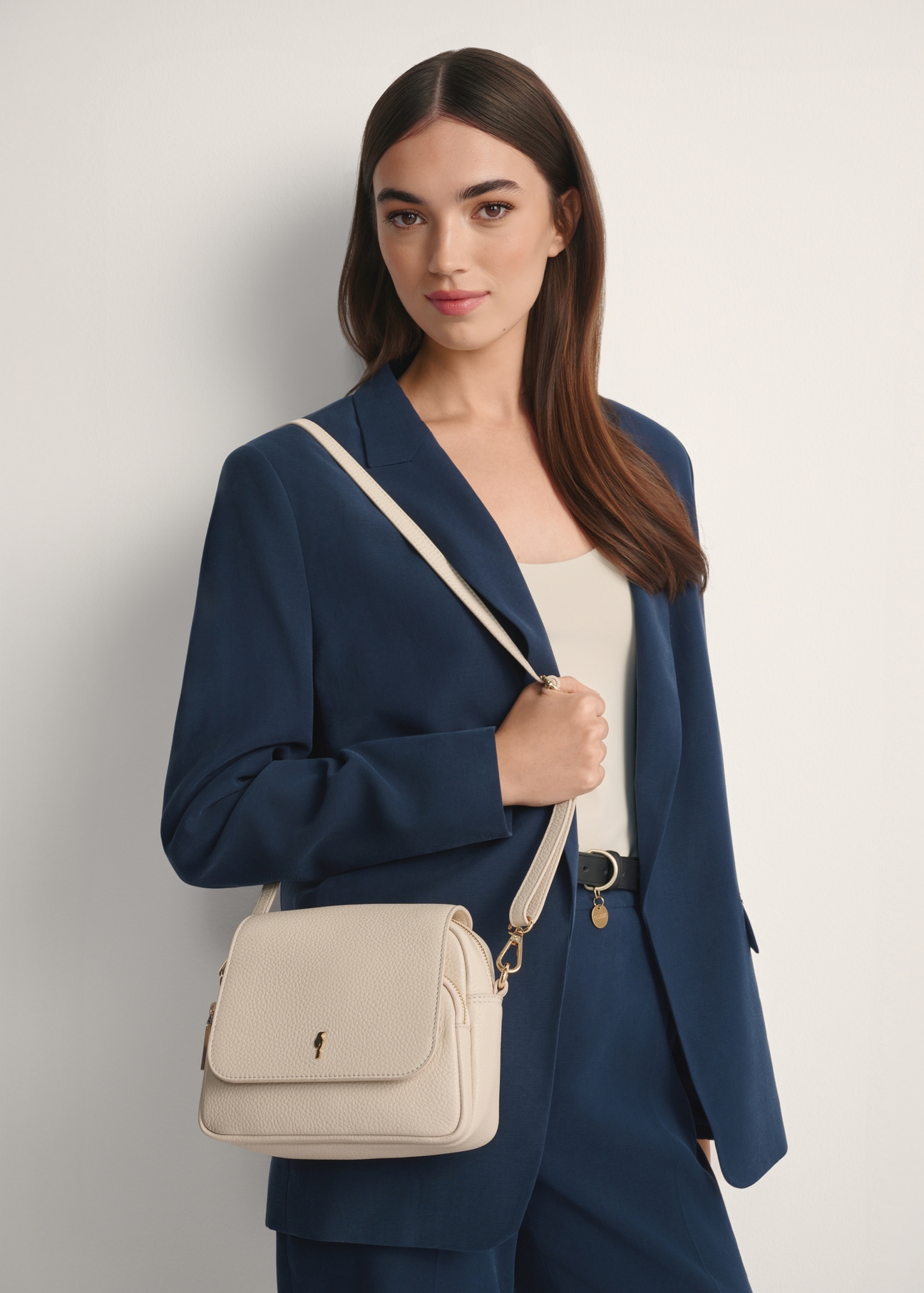 Kremowa skórzana torebka listonoszka damska TORES-0958E-0B(W26), widok produktu od przodu na modelce, widoczna połowa sylwetki.