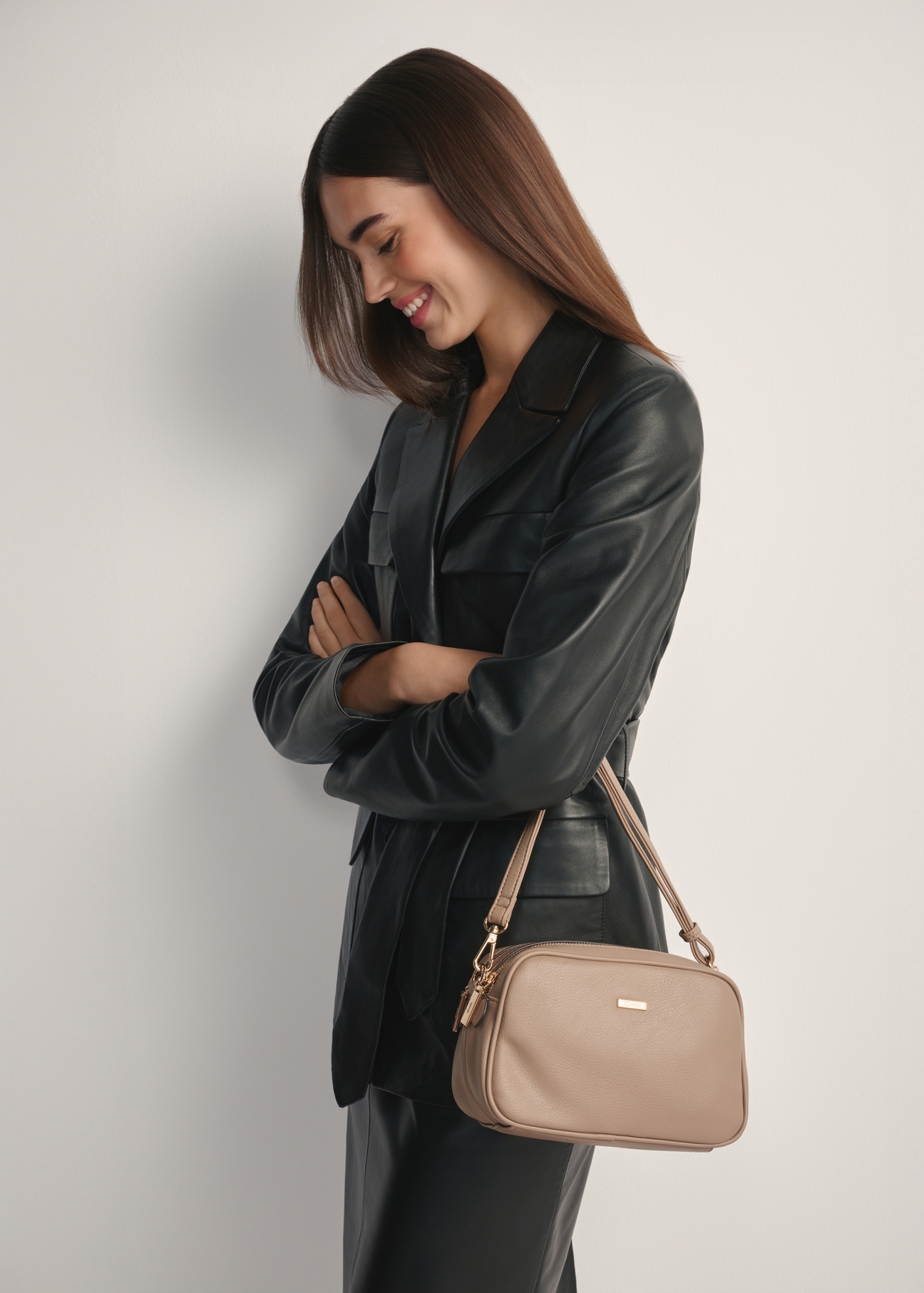 Beżowa średnia torebka damska TOREC-1121-1D(W26), widok produktu od przodu na modelce, widoczna połowa sylwetki.