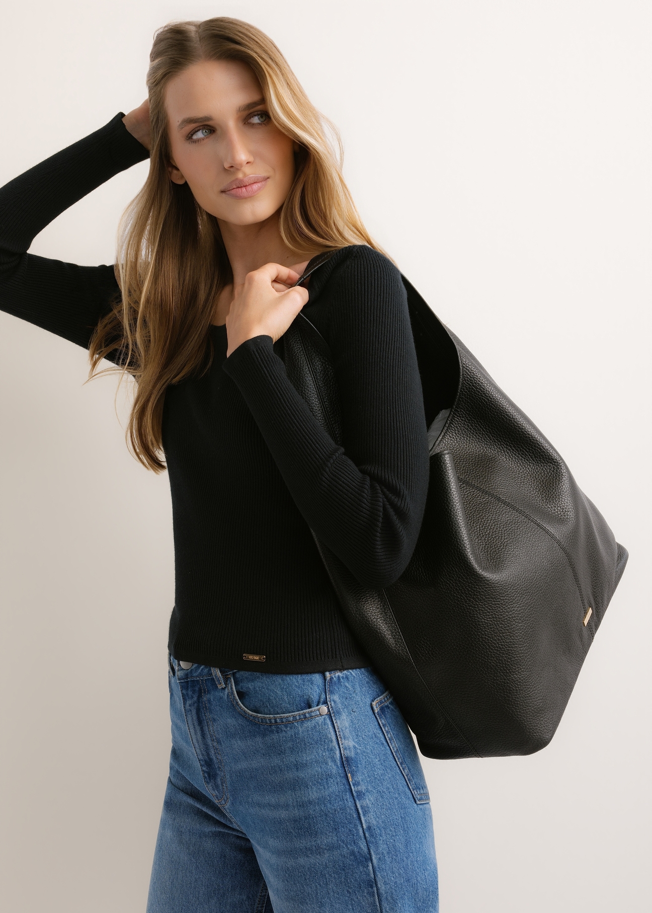 Czarna skórzana torebka shopper TORES-1372-9I(Z26), widok produktu skosem na modelce. Widoczna połowa sylwetki.