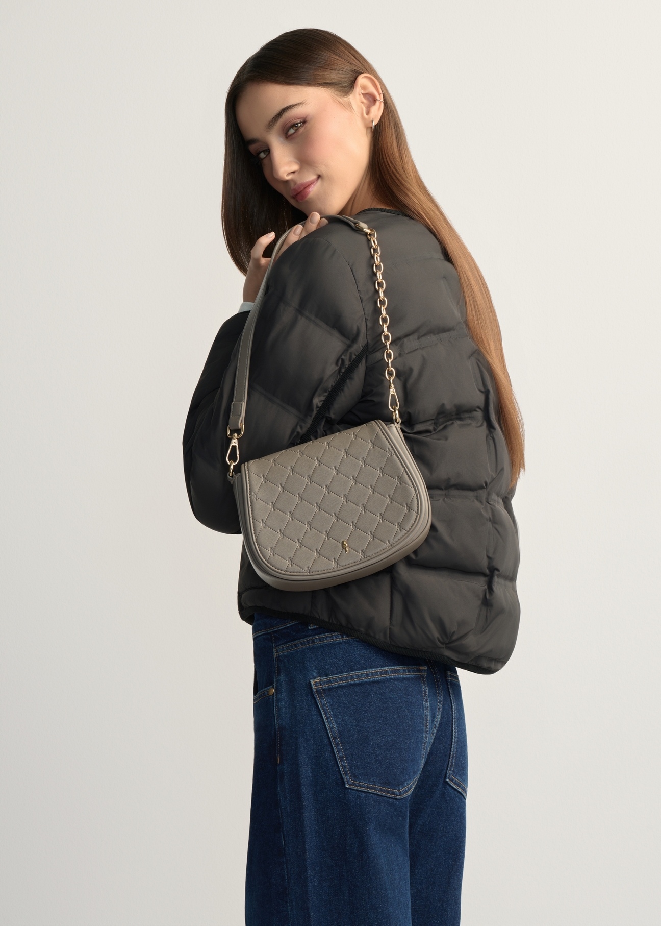 Jasnobrązowa listonoszka damska TOREC-1179-1K(W26), widok produktu na ramieniu modelki. Widoczna połowa sylwetki.