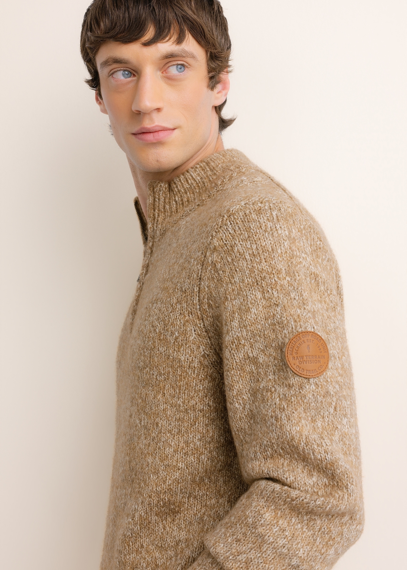 Camelowy sweter męski z wełną SWEMT-0218-1D(Z26), widok produktu z boku na modelu. Widoczna połowa sylwetki.