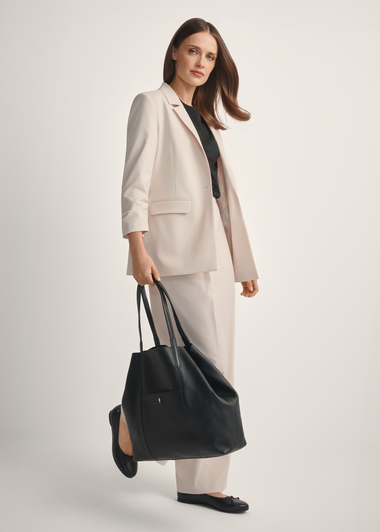 Czarna duża skórzana torebka shopper TORES-1212-9I(W26), widok produktu skosem na modelce, widoczna cała sylwetka.