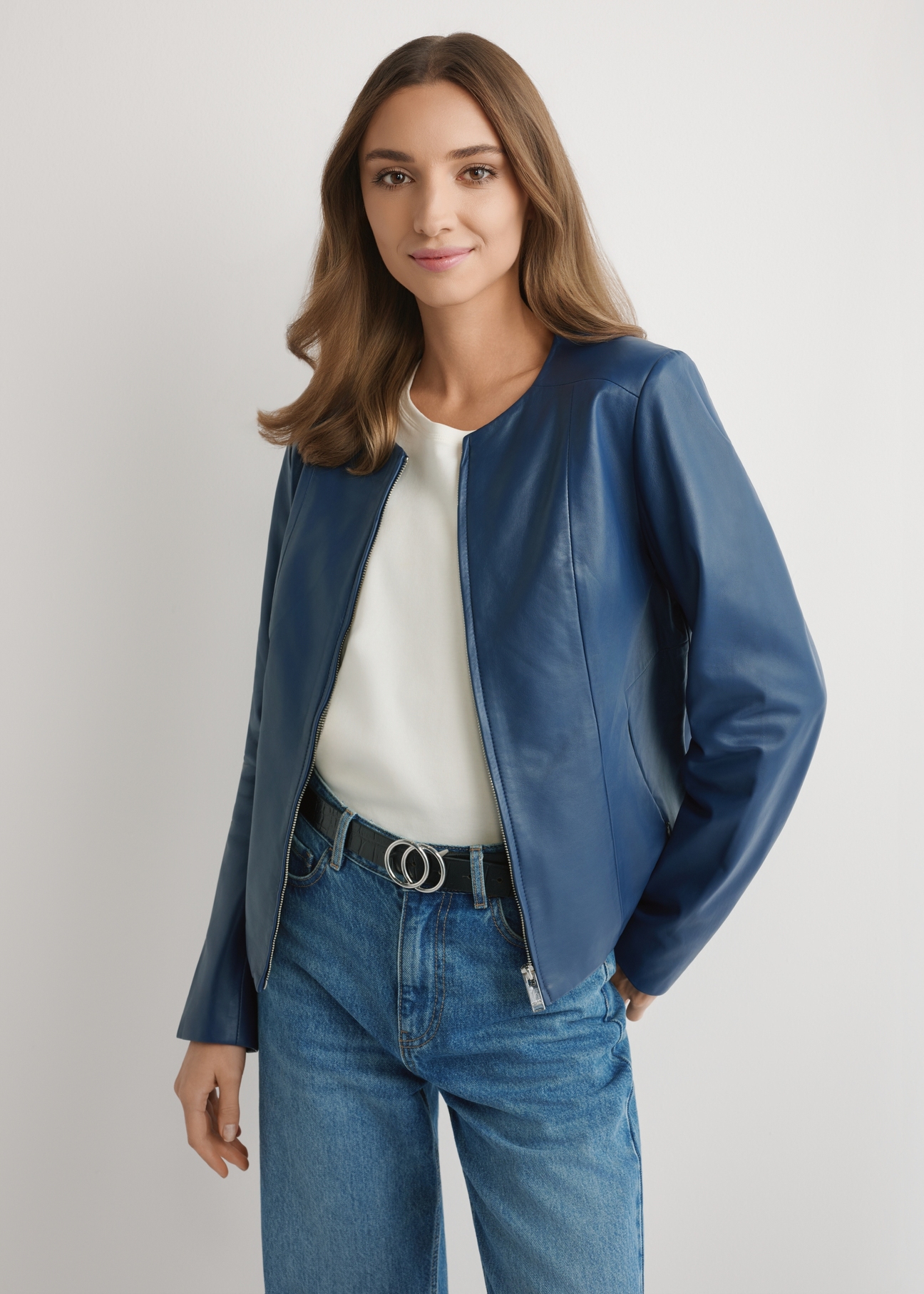 Granatowa skórzana kurtka damska KURDS-0532-7D(W26) - widok produktu z przodu, na modelce, na jasnym tle. Widoczna połowa sylwetki. 