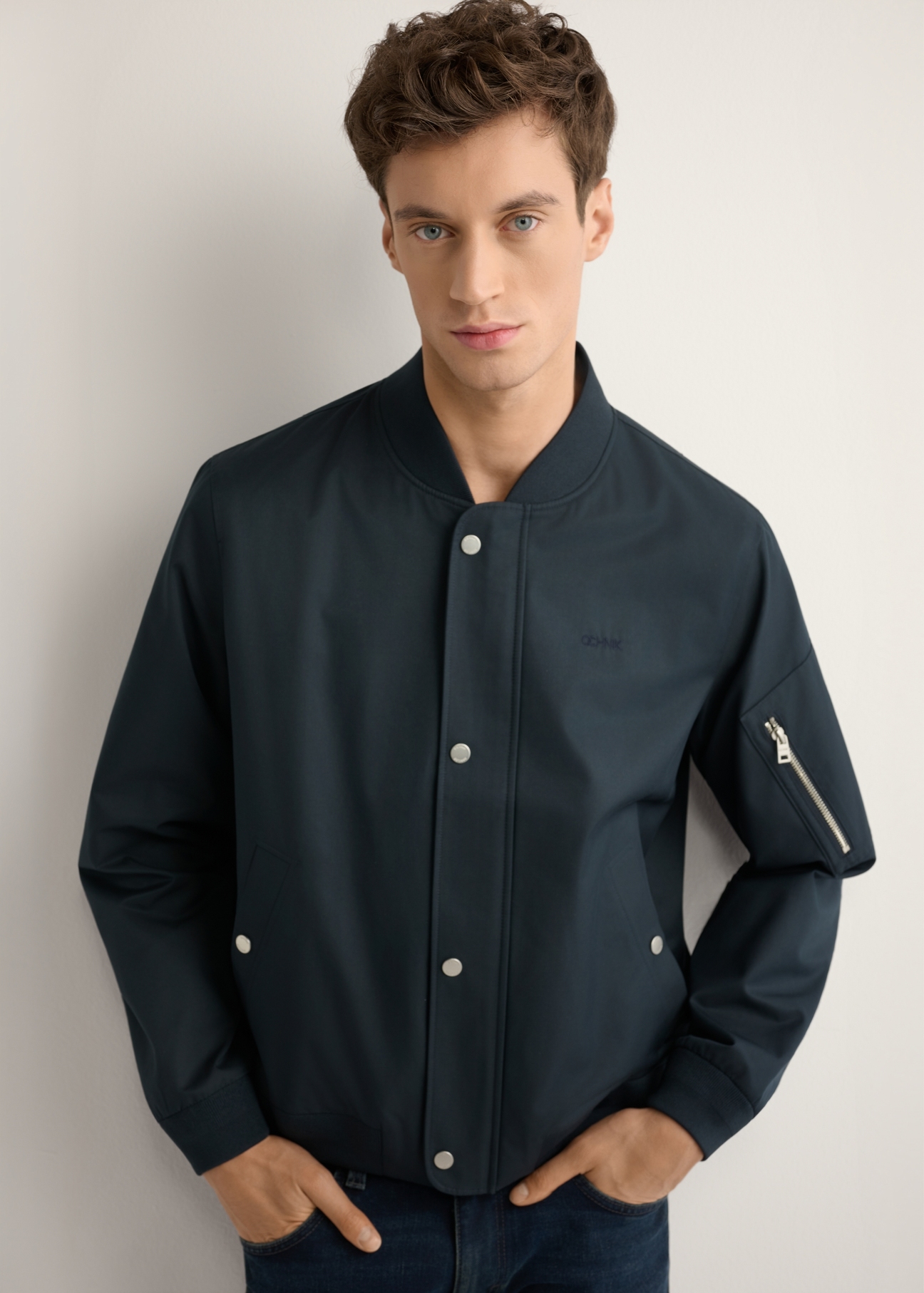 Granatowa przejściowa kurtka męska KURMT-0403-7D(W26), widok produktu z przodu na modelu. Widoczna połowa sylwetki.