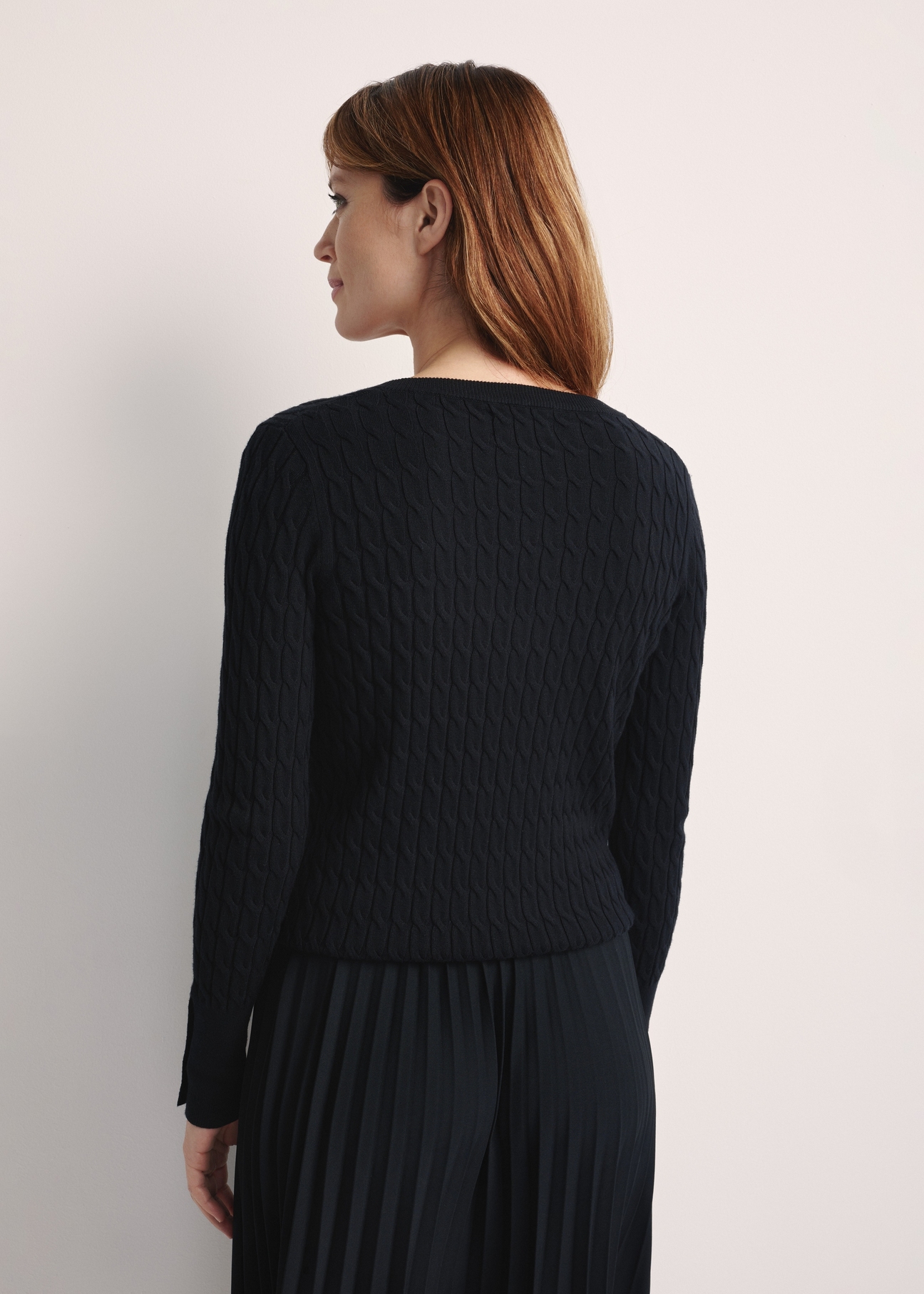 Czarny sweter damski SWEDT-0212A-99(Z25), produktu widoczny od tyłu na modelce, widoczne pół sylwetki.