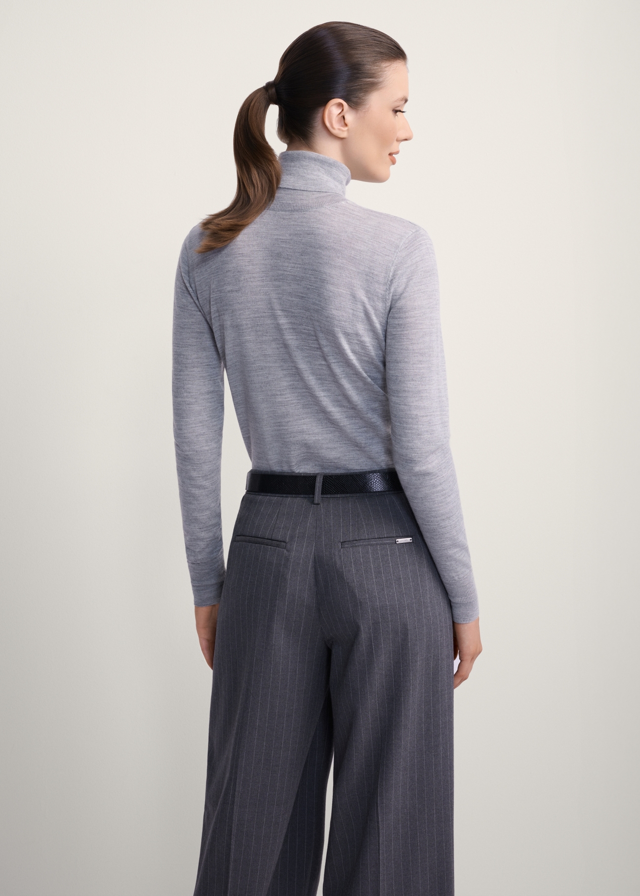 Szary golf damski z wełną SWEDT-0255-91(Z25), widok produktu od tyłu na modelce, widoczna połowa sylwetki.
