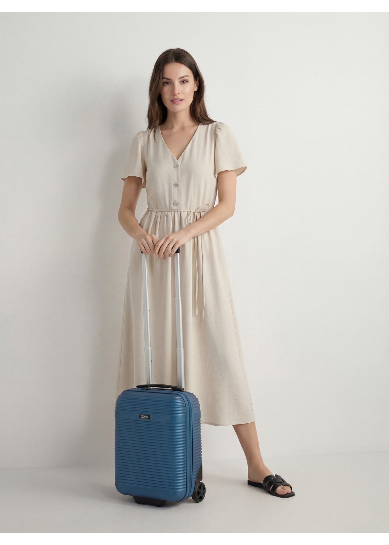 Walizka kabinowa na kółkach WALAB-0040-7H-16(W26), widok produktu skosem przy modelce, widoczna cała sylwetka.