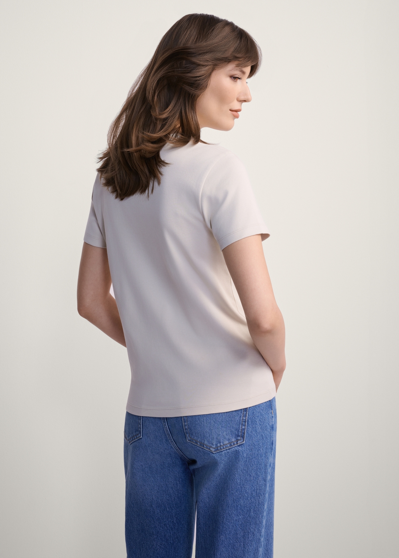 Beżowy bawełniany T-shirt damski TSHDT-0144-80(Z25), widok produktu od tyłu na modelce, widoczna połowa sylwetki.