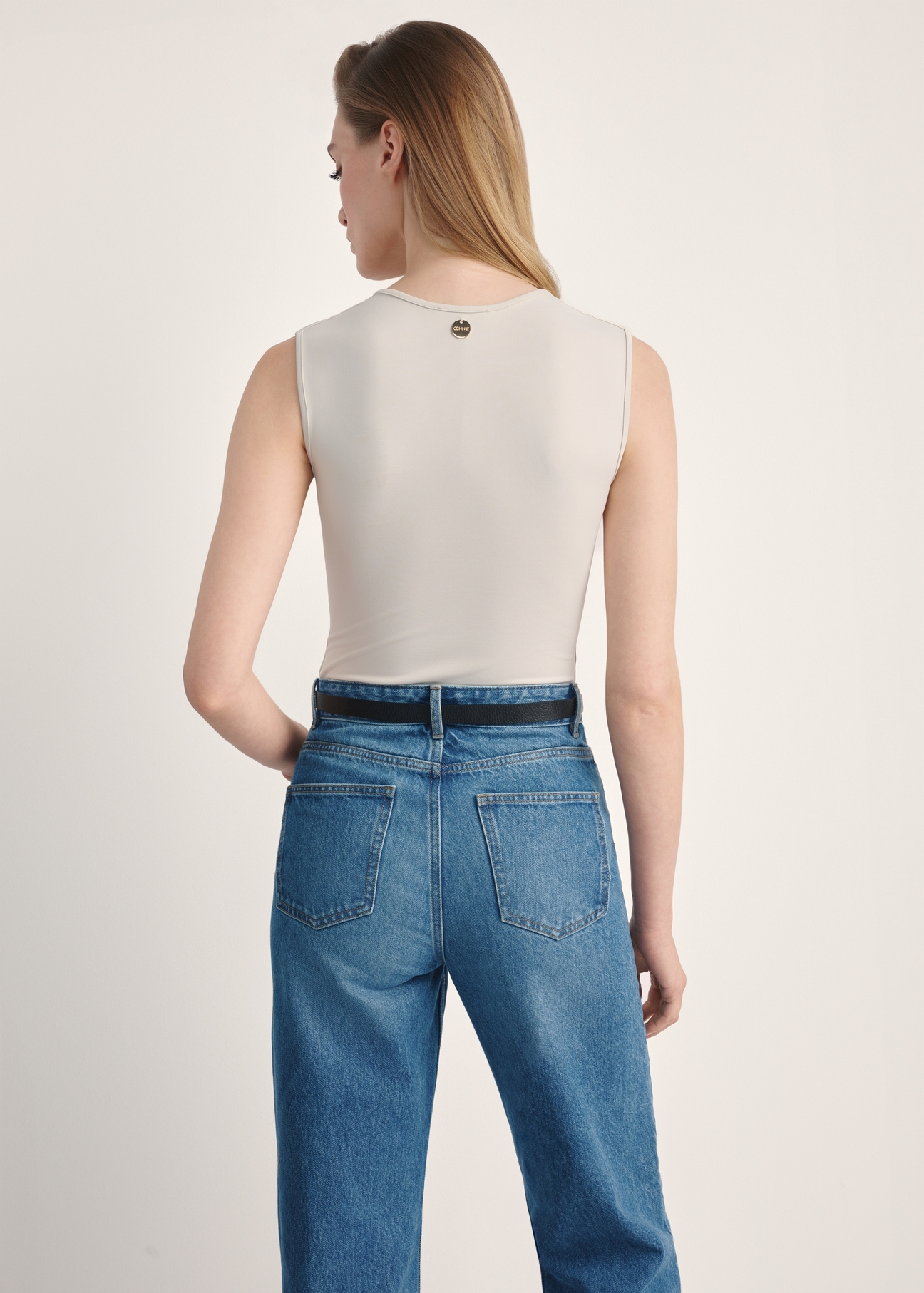 Jasnobeżowe body damskie BODYT-0002-80(Z25), produkt widoczny od tyłu na modelce, widoczne pół sylwetki.