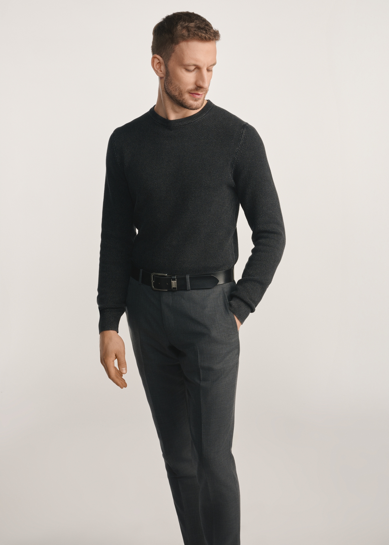 Sweter męski w kolorze czarnym SWEMT-0181-99(Z25), widok produktu z przodu na modelu. Widoczna połowa sylwetki.
