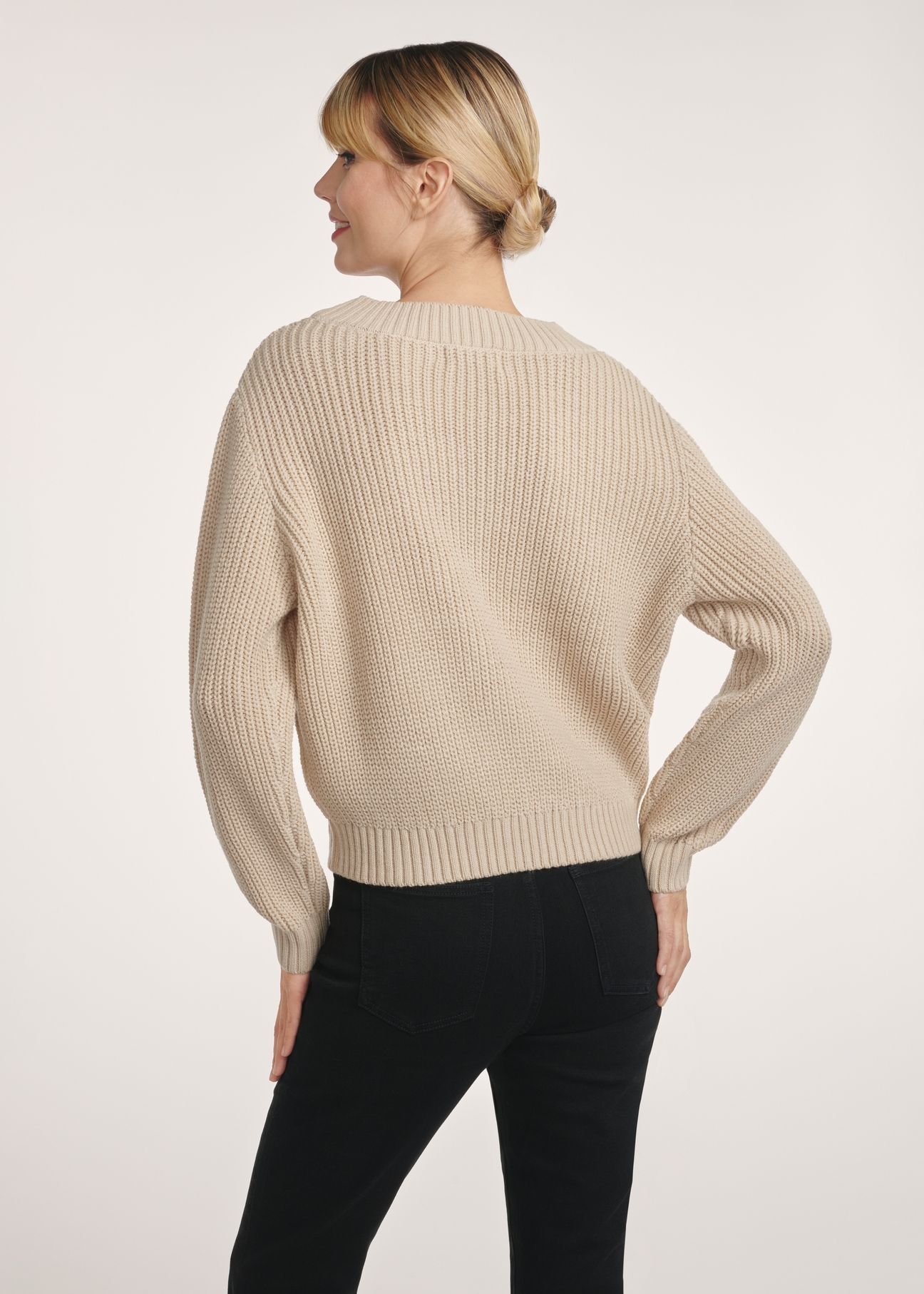 Beżowy sweter dekolt V damski SWEDT-0162-80(Z25), produkt widoczny z tyłu na modelce, widoczne pół sylwetki.