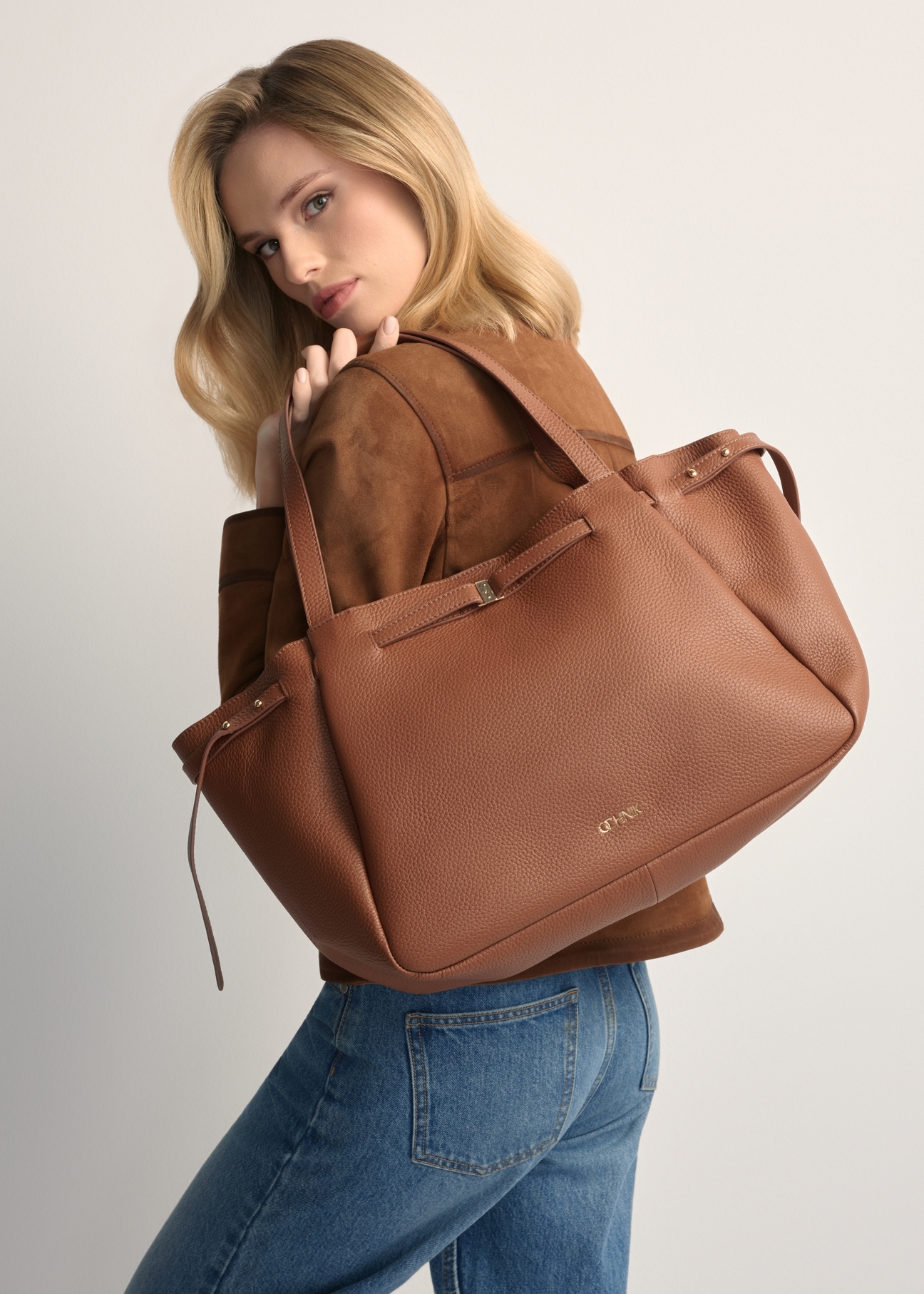 Skórzana torebka shopper w kolorze camelu TORES-1207-1D(W26), widok produktu na ramieniu modelki. Widoczna połowa sylwetki.
