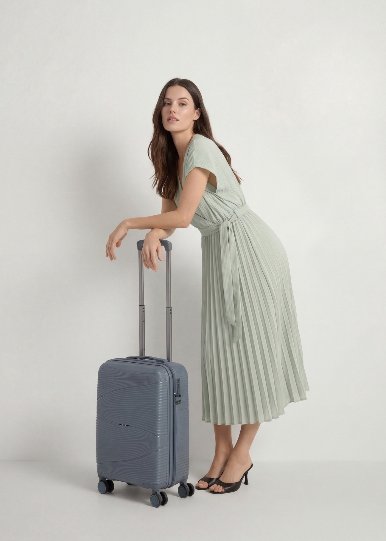 Walizka mała na kółkach WALPP-0021-9B-19(W26), widok produktu skosem obok sylwetki modelki.