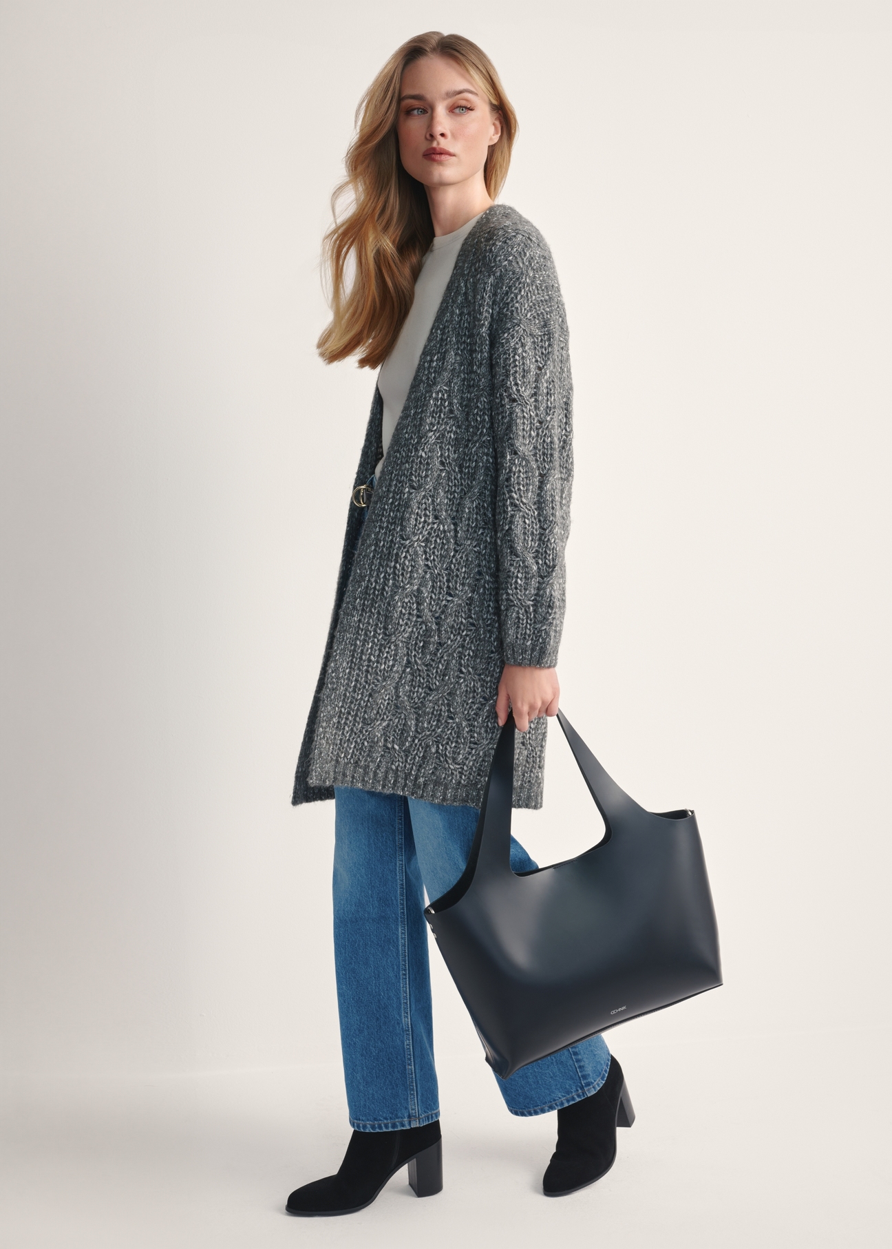 Czarna duża skórzana torebka shopper TORES-1140-99(Z25), widok produktu w dłoni modelki na jasnym tle.