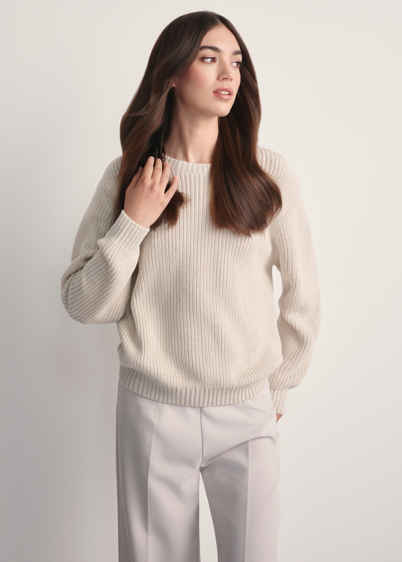 Beżowy sweter damski SWEDT-0238-81(Z25), widok produktu z przodu na modelce. Widoczna połowa sylwetki.