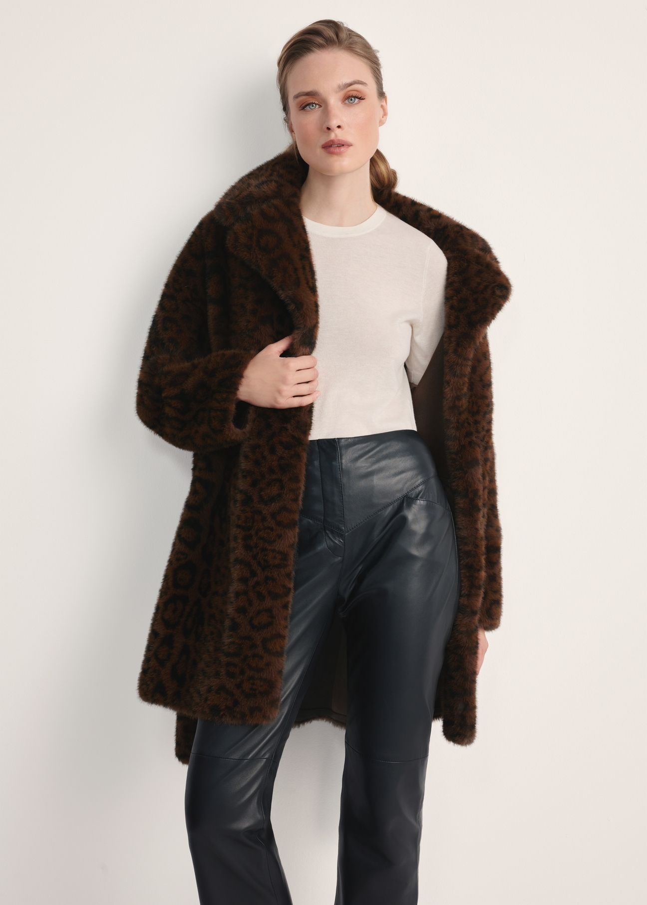 Brązowe futro damskie w panterkę FUTDP-0074-89(Z25) - widok produktu z przodu na modelce, na białym tle. Widoczna sylwetka do kolan. 