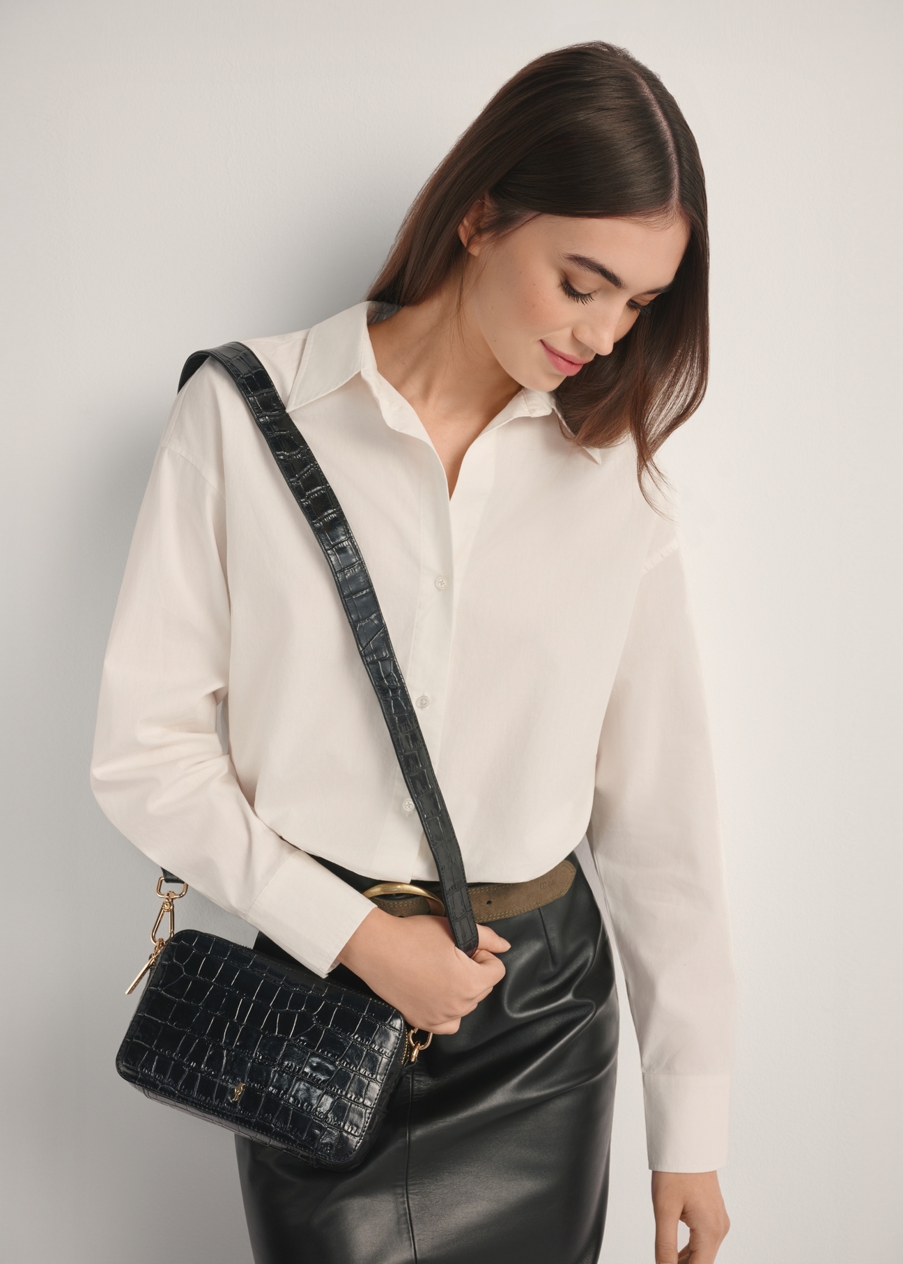 Mała czarna skórzana torebka croco TORES-1231-9G(W26), widok produktu na ramieniu modelki. Widoczna połowa sylwetki.