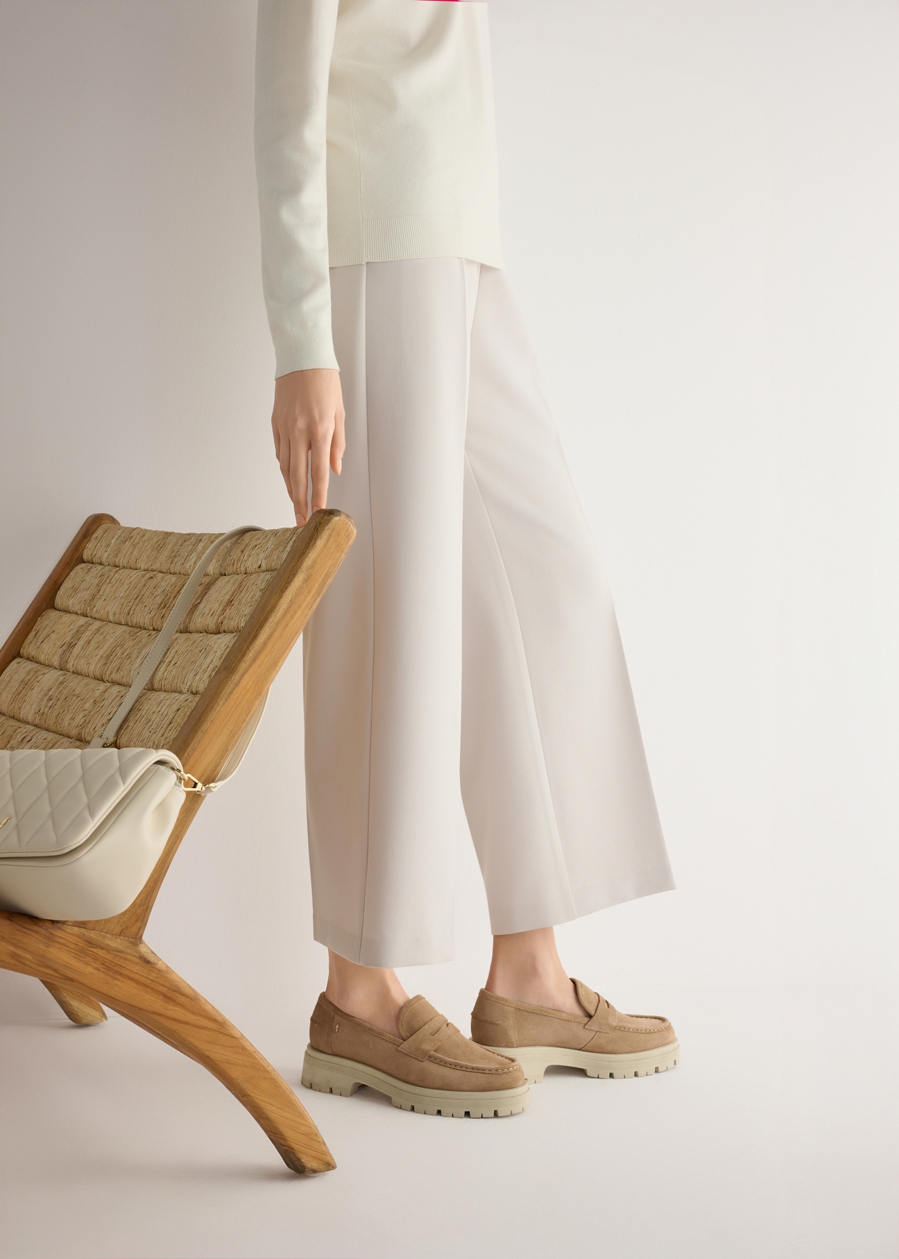 Skórzane mokasyny na platformie w kolorze beżowym BUTYD-1069-1B(W26), widok produktu od boku na modelce, widoczna połowa sylwetki.