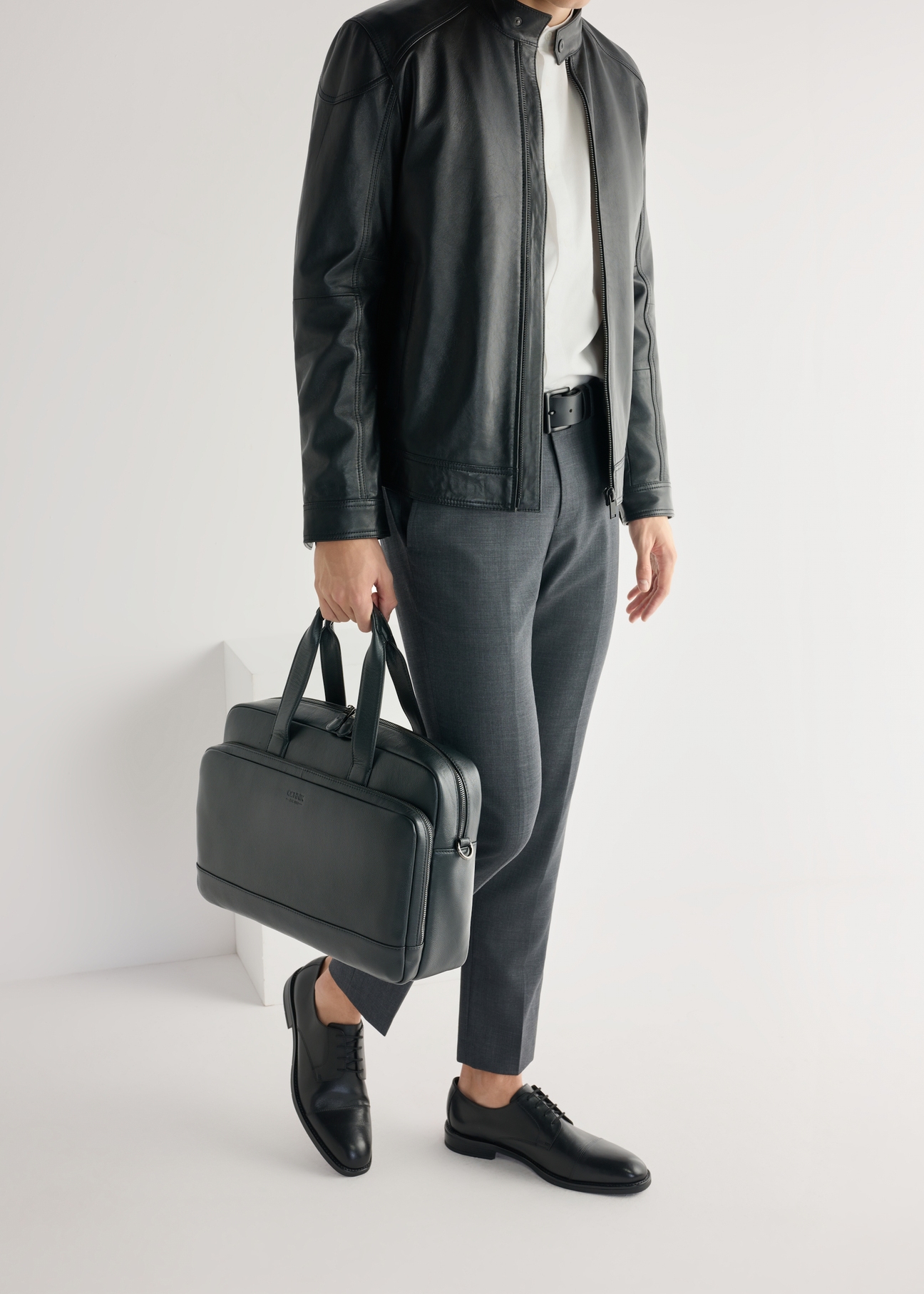 Czarne skórzane półbuty męskie BUTYM-0500-99(W25), widok produktu z boku na stopach modela.