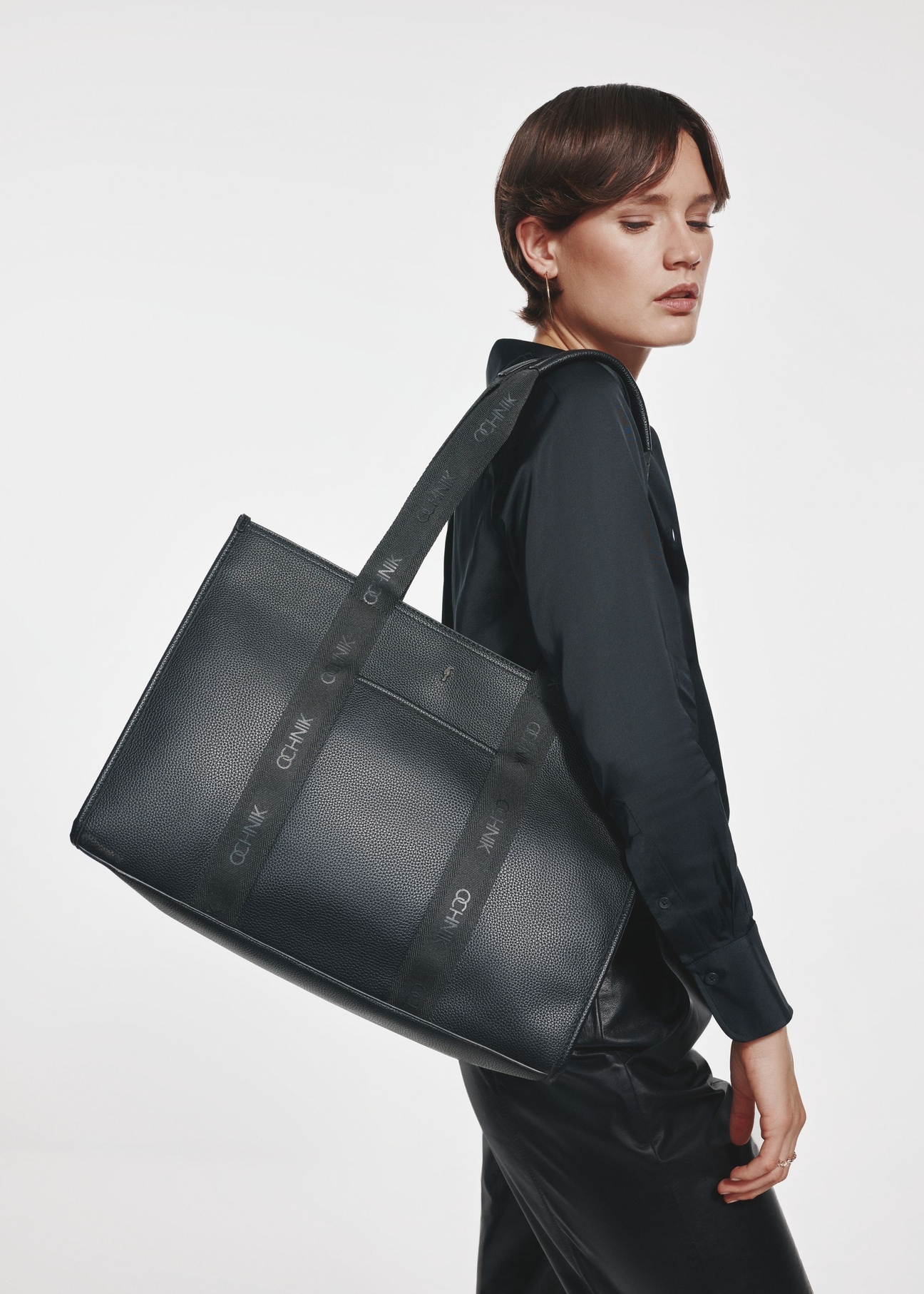 Czarna duża torebka shopper TOREC-0977A-99(Z25) - widok produktu z przodu na modelce na białym tle. 