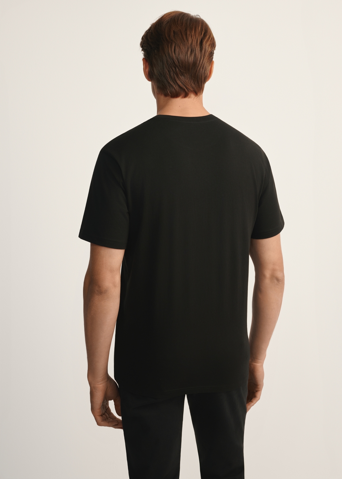 Czarny T-shirt męski z nadrukiem TSHMT-0132-99(Z25), widok produktu od tyłu na modelu, widoczna połowa sylwetki.