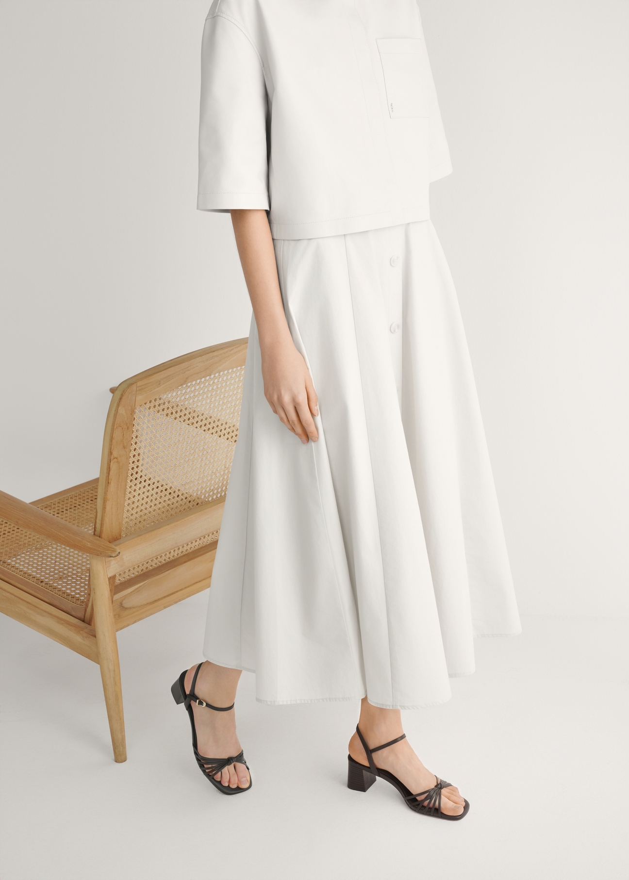 Ciemnobrązowe skórzane sandały na słupku BUTYD-1234-1IW26), widok produktu z boku na stopach modelki.