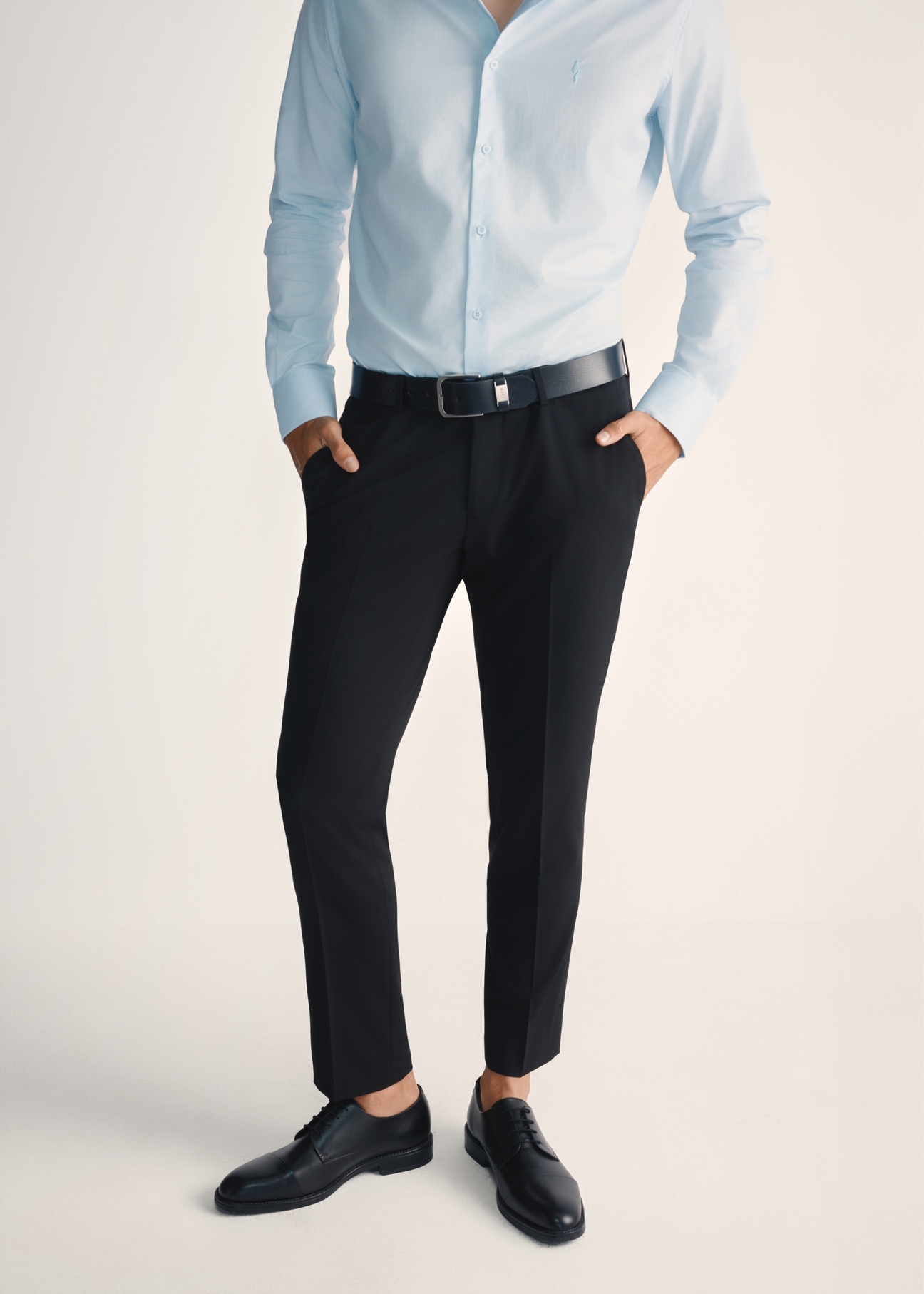 Czarne skórzane półbuty męskie BUTYM-0512-99(Z25), widok produktu z przodu na stopach modelu na jasnym tle.