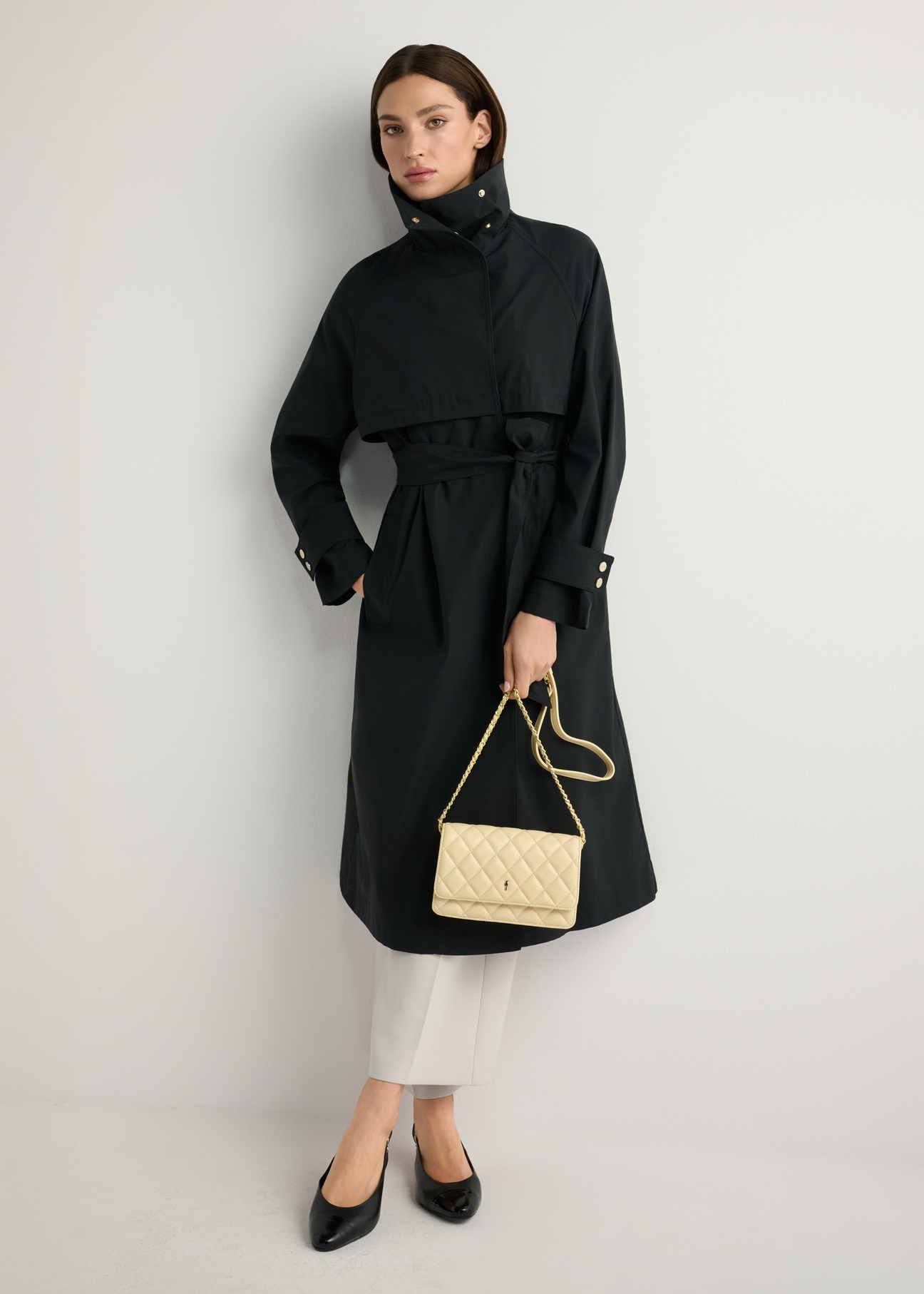 Żółta mała pikowana torebka damska TOREC-1033-2A(W26), widok produktu w dłoni modelki. Widoczna cała sylwetka.