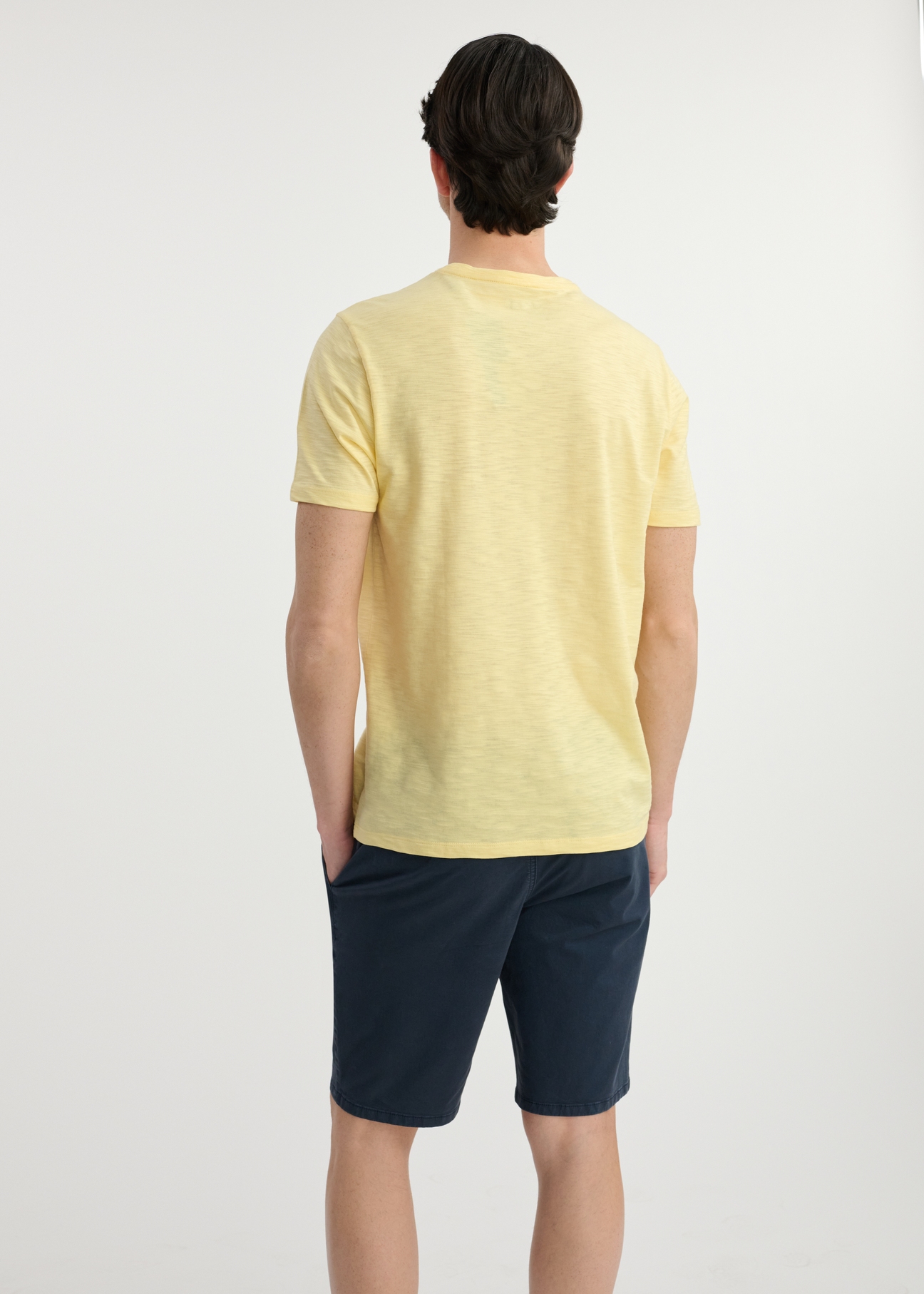 Żółty bawełniany t-shirt męski TSHMT-0121-21(W25), widok produktu tyłem na modelu. Widoczna połowa sylwetki.
