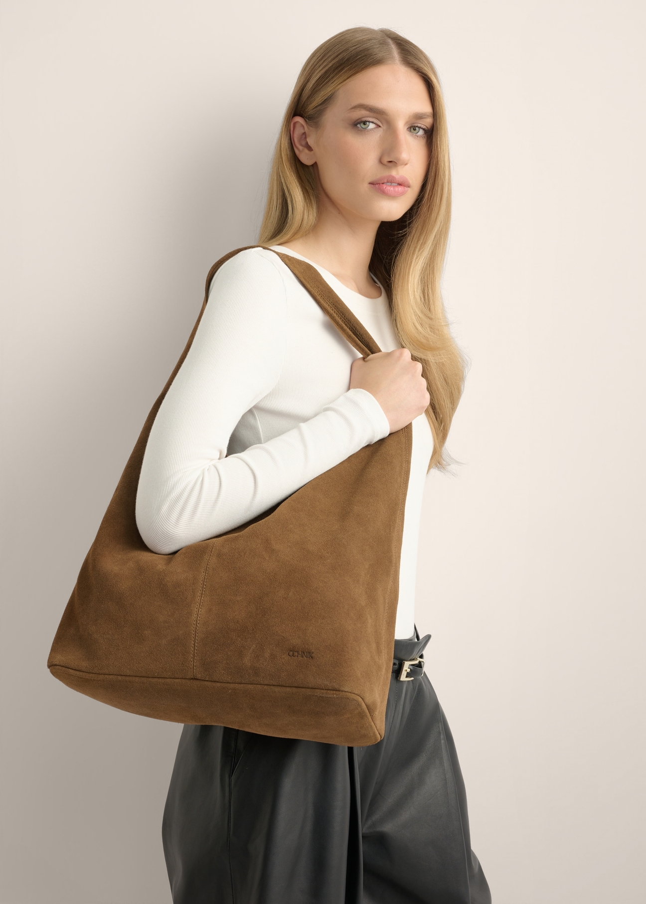Zamszowa torebka shopper w kolorze koniaku TORES-1403-1F(Z26), widok produktu od przodu na modelce. Widoczna połowa sylwetki.