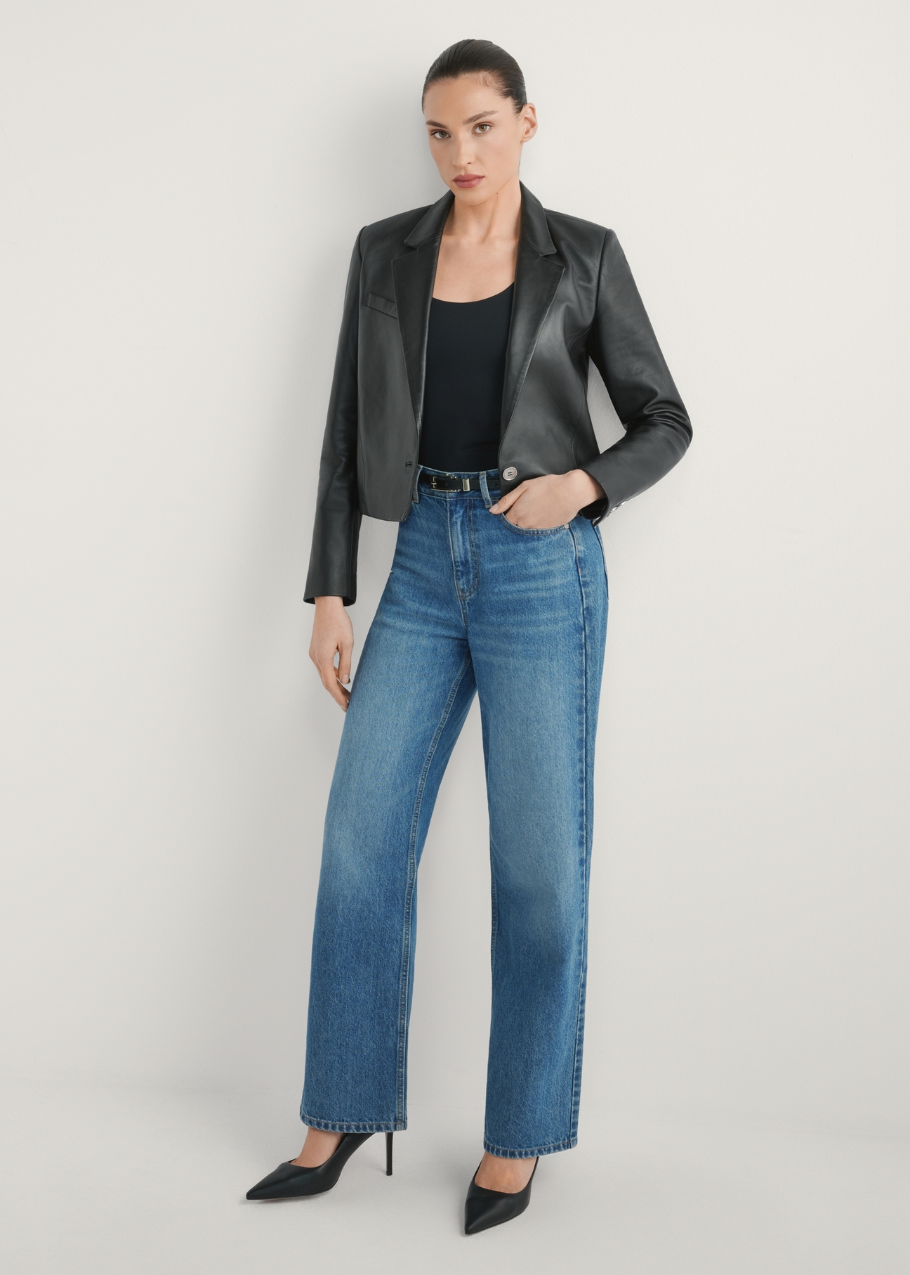 Krótka skórzana marynarka damska KURDS-0522-99(W26) - widok produktu z przodu, na modelce, na jasnym tle. Widoczna cała sylwetka.