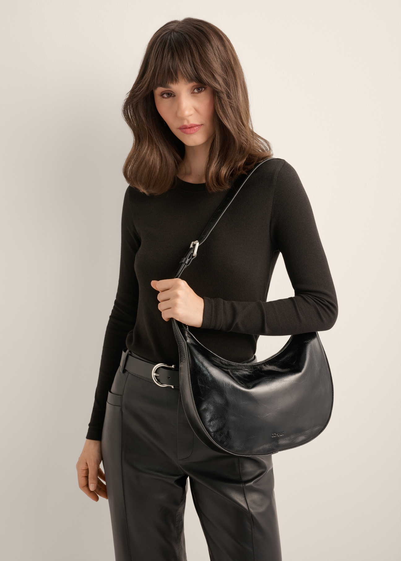 Torebka damska hobo z połyskiem TORES-1366-9F(Z26), widok produktu od przodu na modelce. Widoczna połowa sylwetki.
