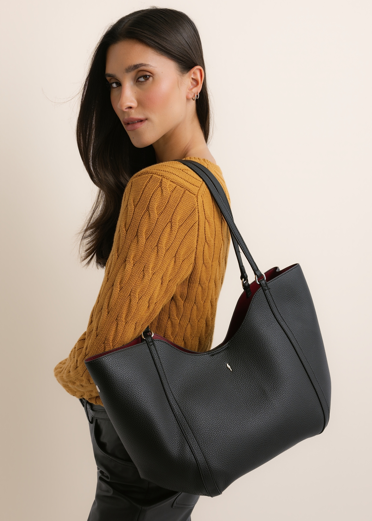 Czarna torebka damska typu shopper TOREC-1296-9I(Z26), widok produktu z przodu, na modelce, na jasnym tle. Widoczna połowa sylwetka.