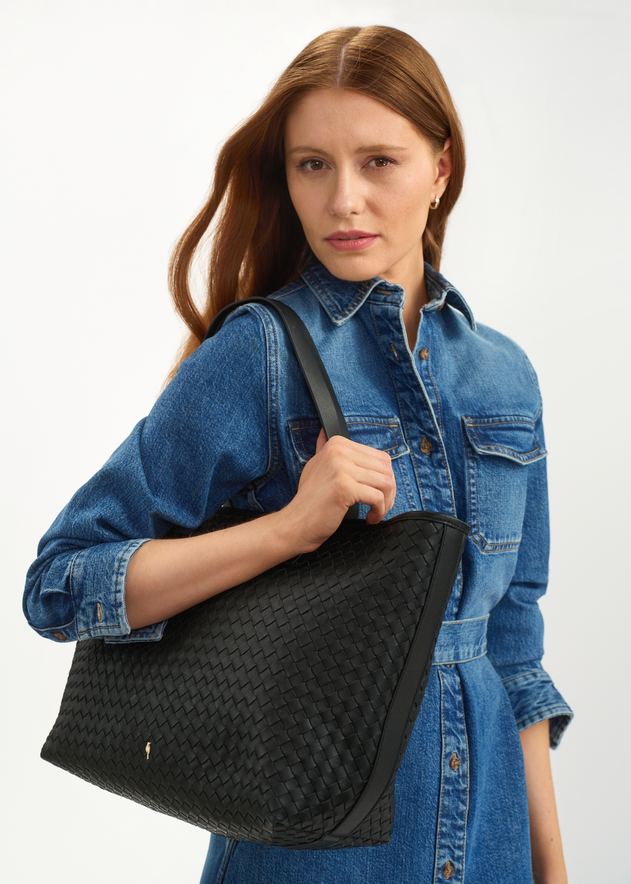 Skórzana czarna torebka shopper damska TORES-1107-99(W25), widok skosu na sylwetce modelki, na białym tle.