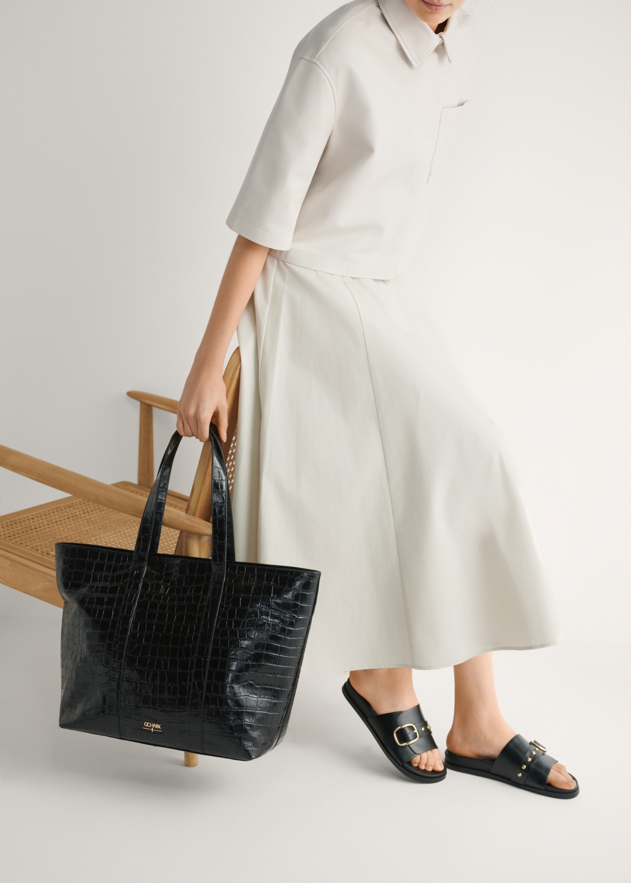 Czarne skórzane klapki damskie BUTYD-1269-99(W26), widok produktu z boku na stopach modelki.