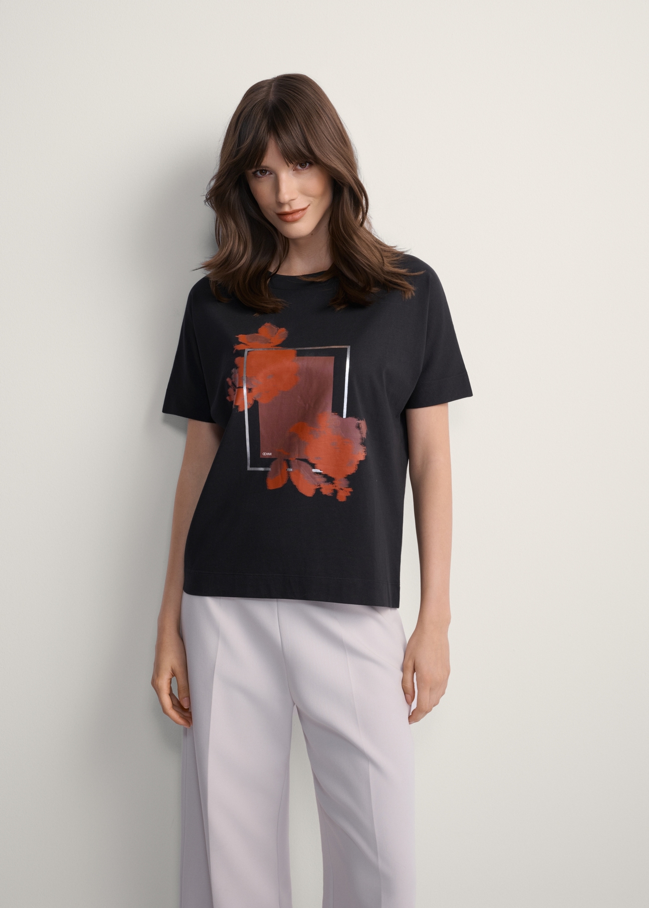 Czarny t-shirt damski z nadrukiem TSHDT-0146-99(Z25), widok produktu z przodu na modelce. Widoczna połowa sylwetki.