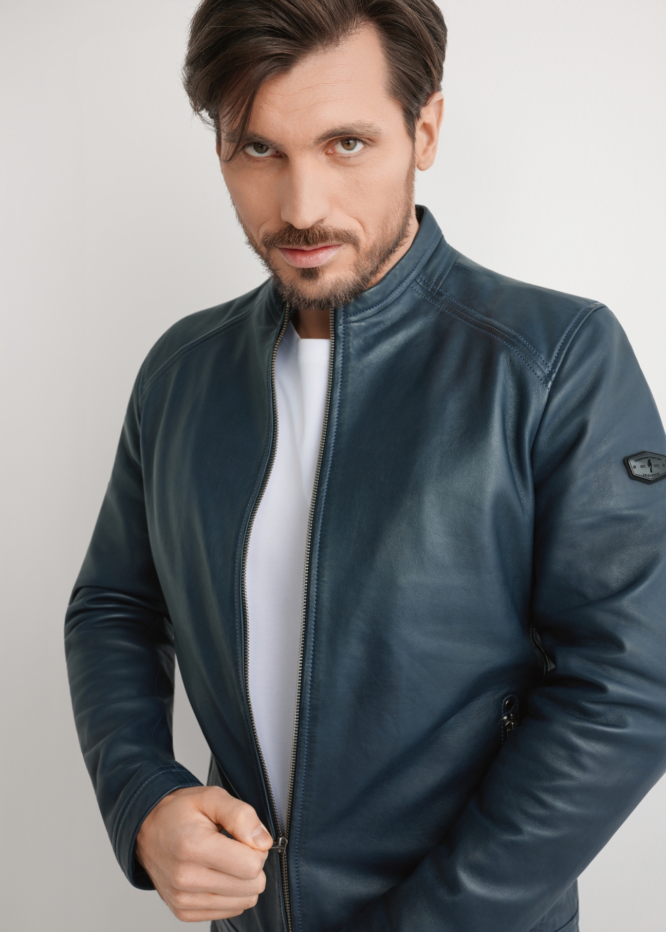 Granatowa skórzana kurtka męska KURMS-0329-7E(W26) - widok produktu z przodu na modelu, na jasnym tle. Widoczna połowa sylwetki. 