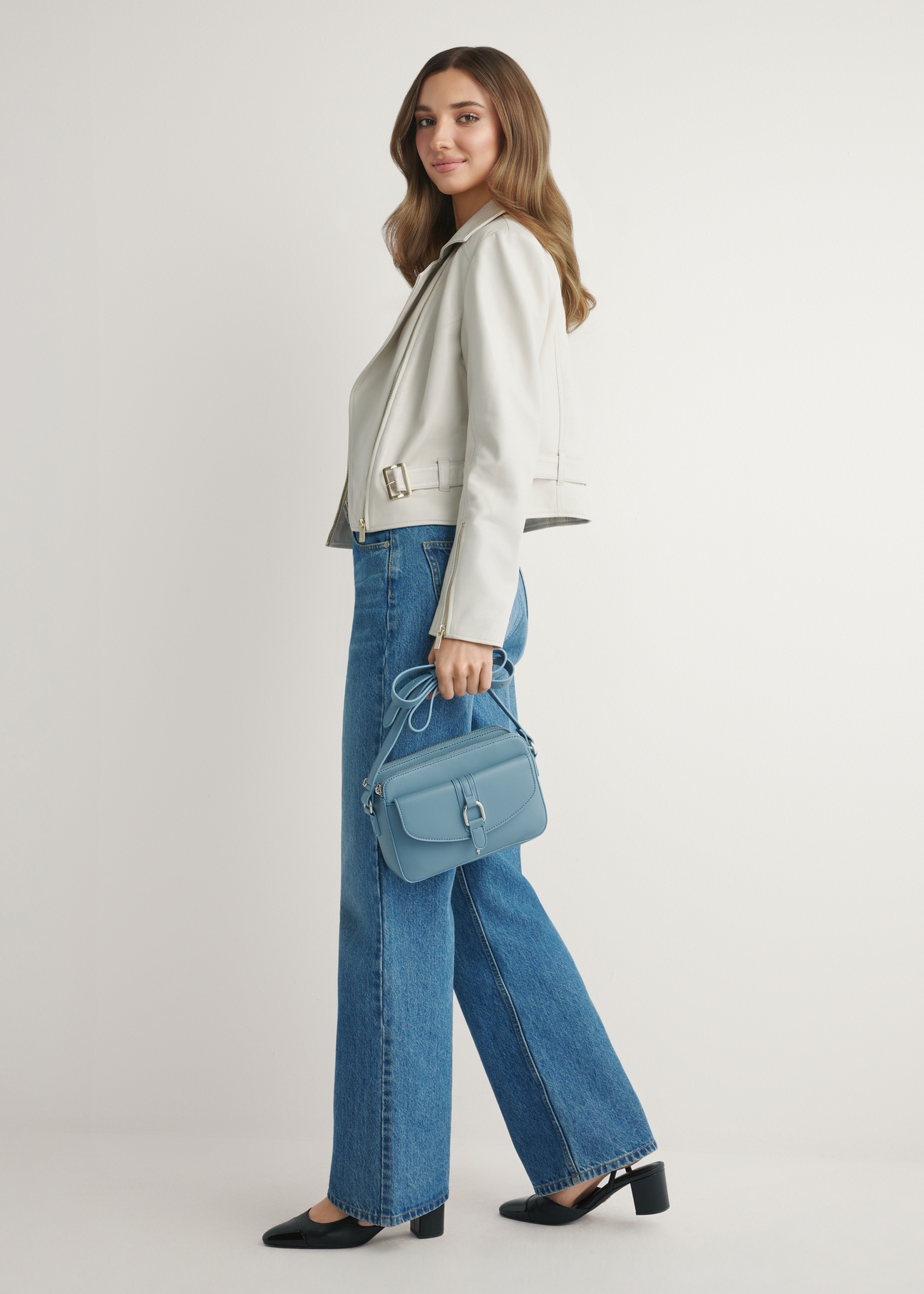 Niebieska mała torebka damska TOREC-1175-7C(W26) - widok produktu z przodu, na modelce, na jasnym tle. Widoczna cała sylwetka. 