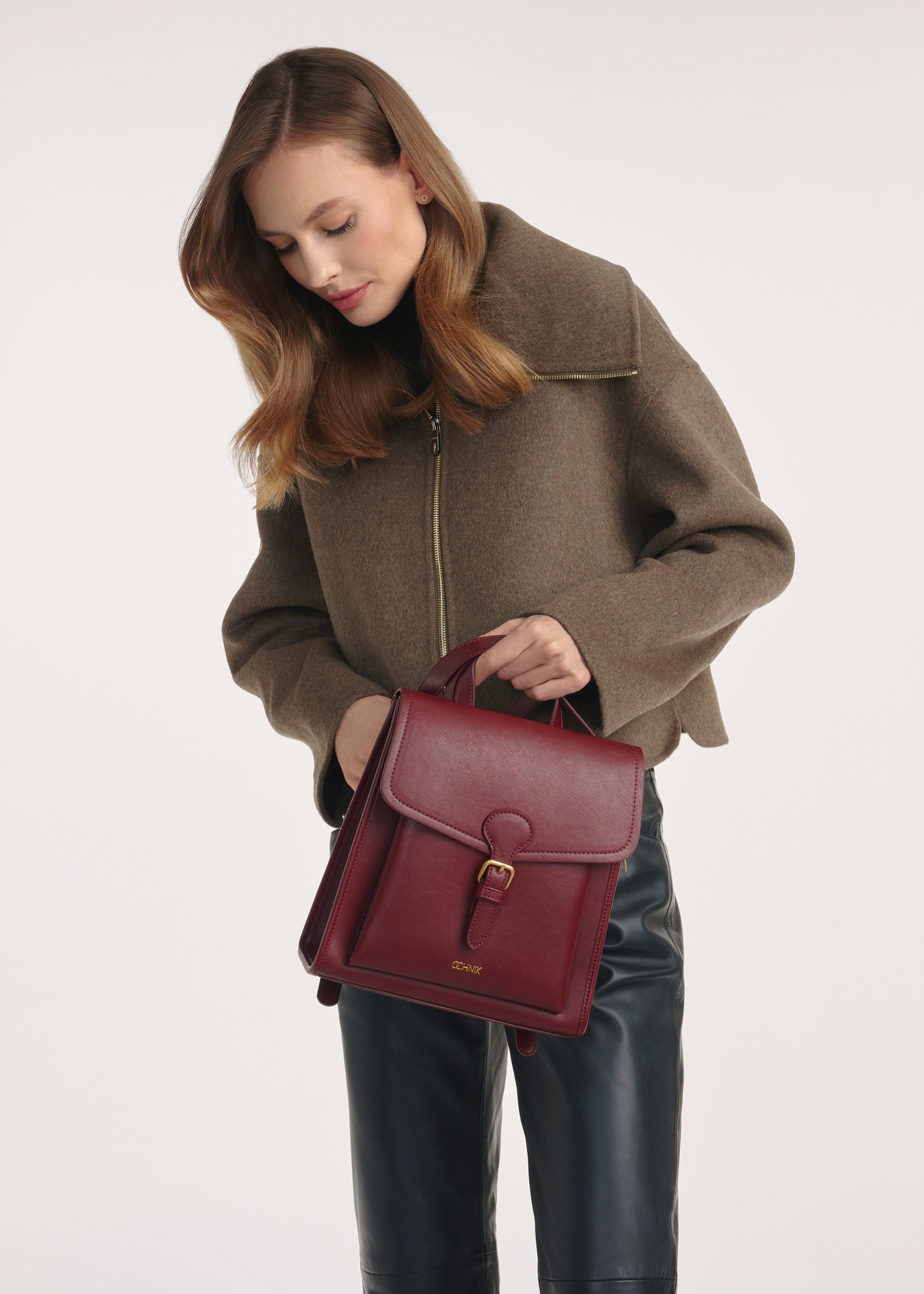 Bordowy średni elegancki plecak damski TOREC-0985A-49(Z25), widok produtku przodem. Widoczna połowa sylwetki modelki.