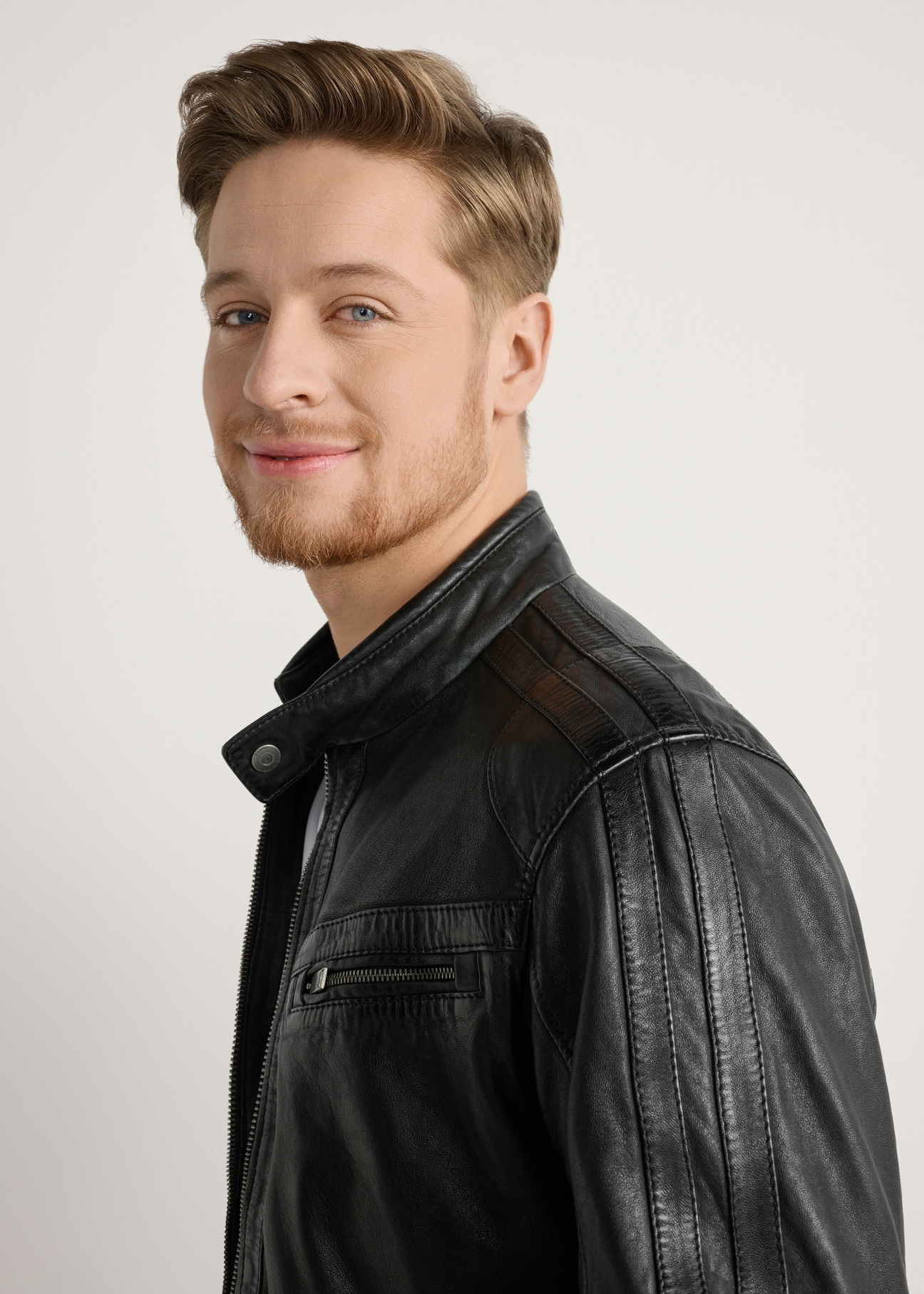 Skórzana kurtka męska w kolorze czarnym KURMS-0397-99(W26) - zbliżenie na modelu, na jasnym tle. 