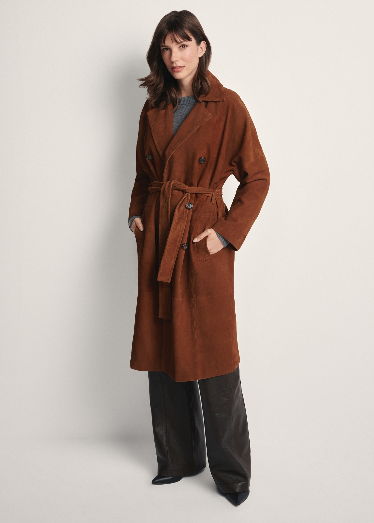 Brązowy zamszowy płaszcz damski oversize KURDS-0551-0775(Z25), widok produktu z przodu na modelce. Widoczna cała sylwetka.